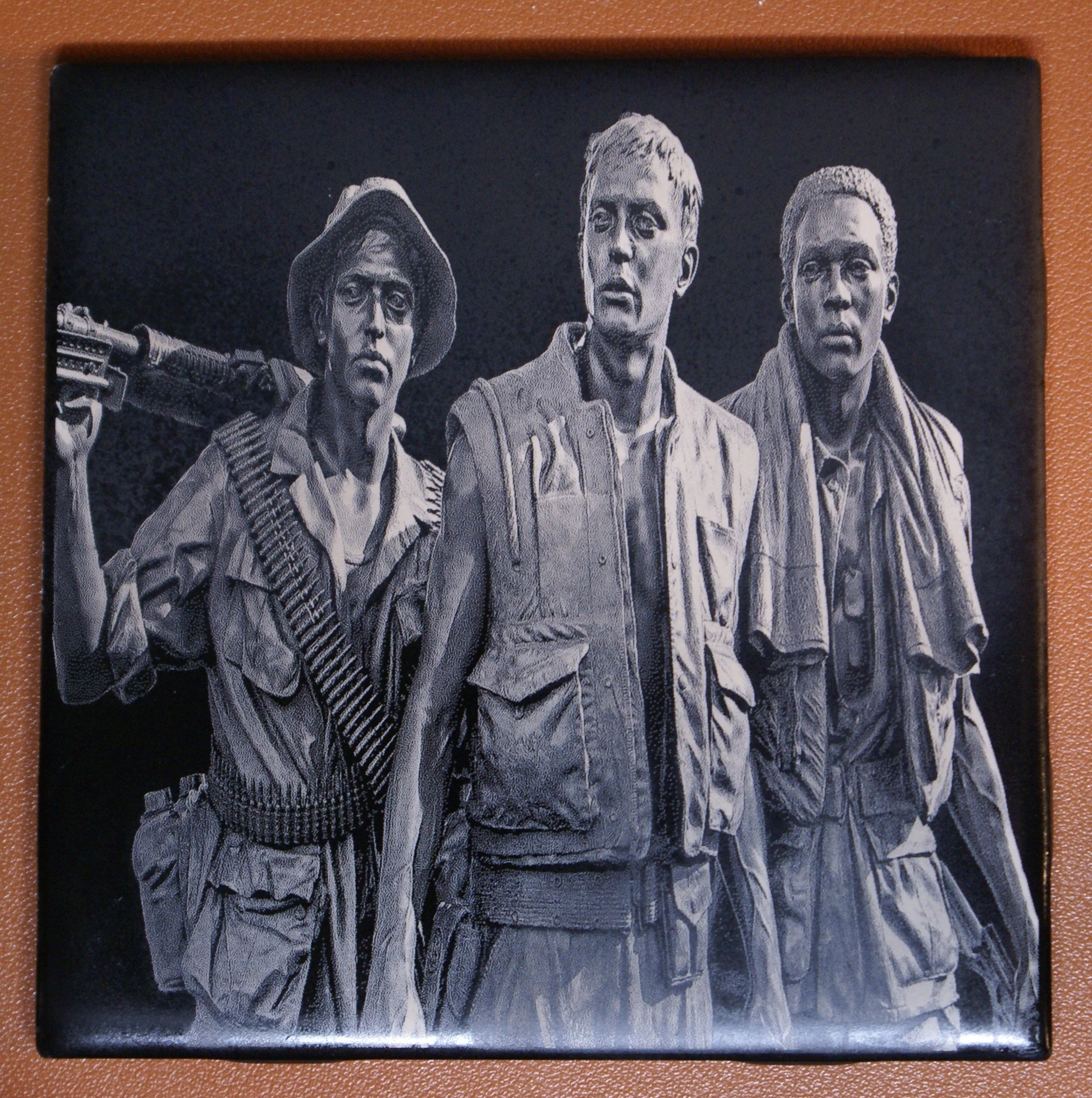 Black and white image of three soldiers in military gear, two men and one woman, with one holding a rifle over her shoulder.