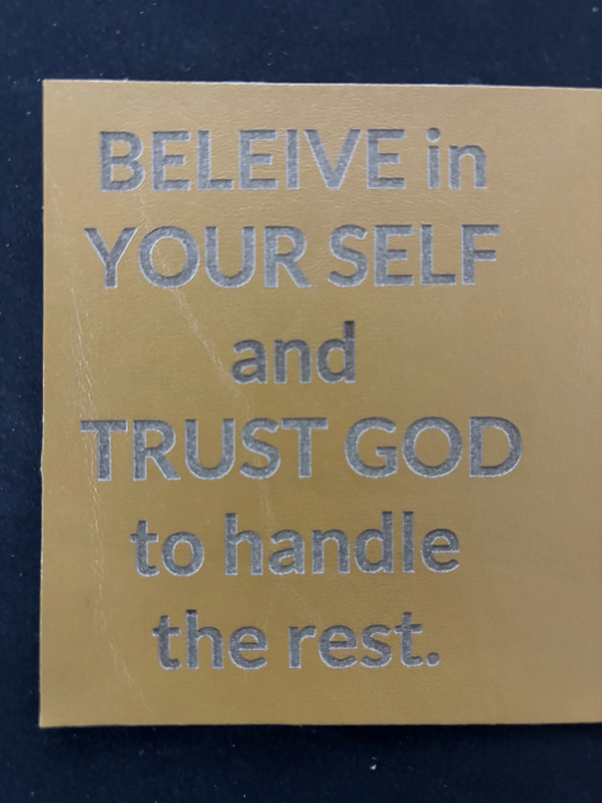 Inspirational quote on a gold background that reads 'BELIEVE in YOURSELF and TRUST GOD to handle the rest.'