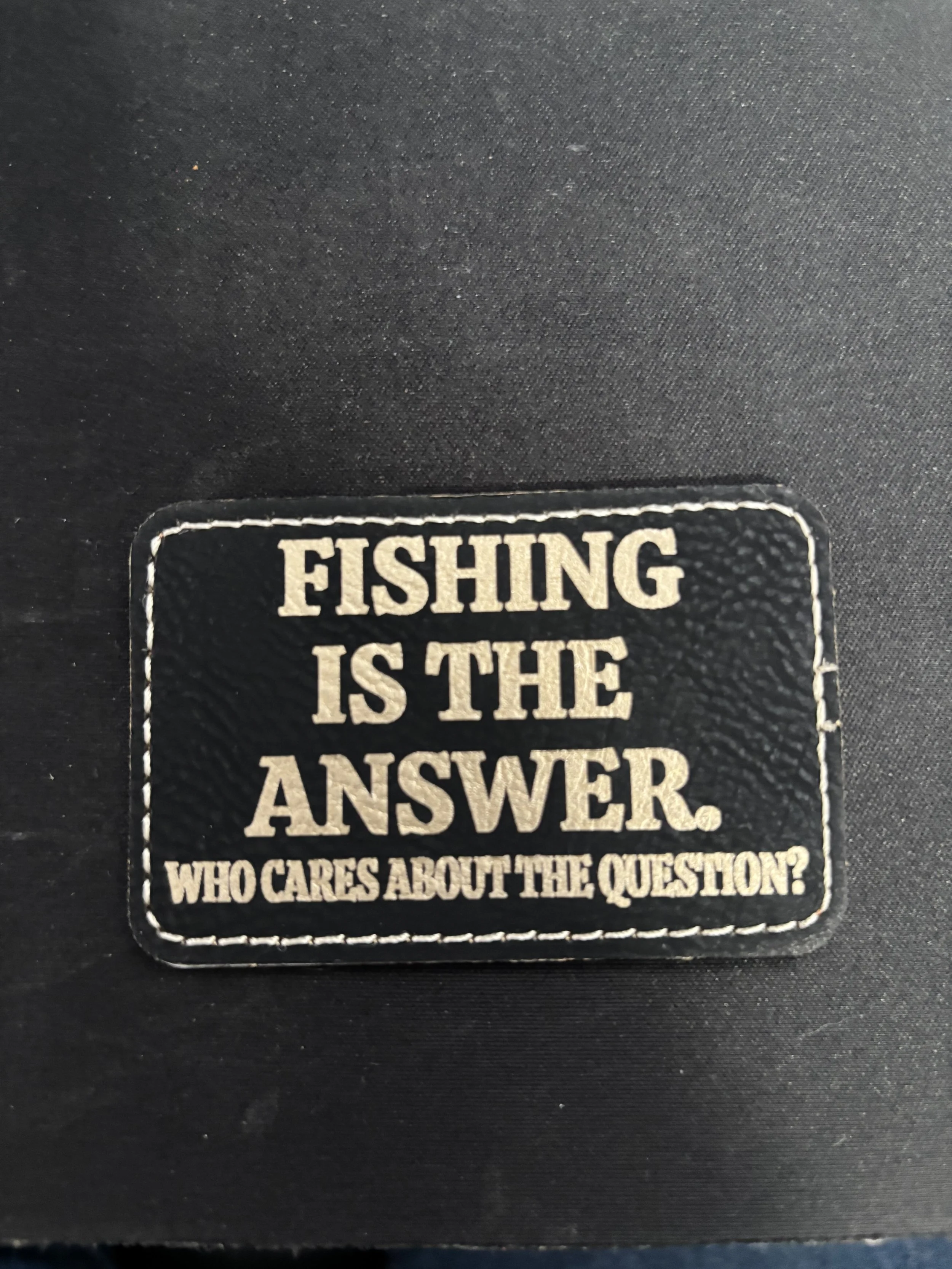 A patch that reads 'Fishing is the answer. Who cares about the question?'