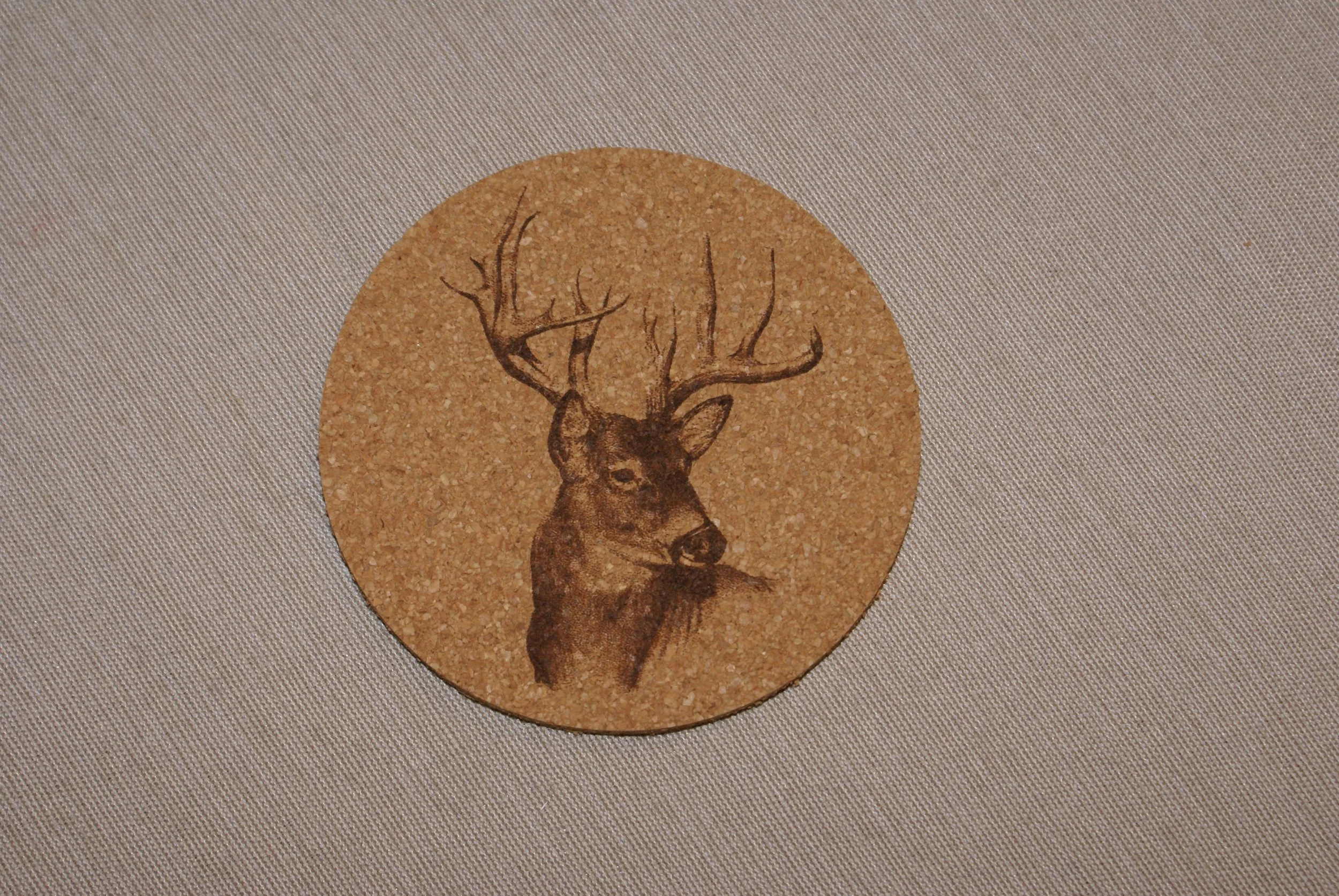 A cork coaster with an illustration of a deer head with antlers