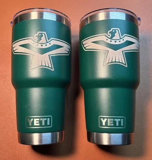 Custom green YETI tumblers engraved with a school's eagle—personalized for a customer fund raiser.