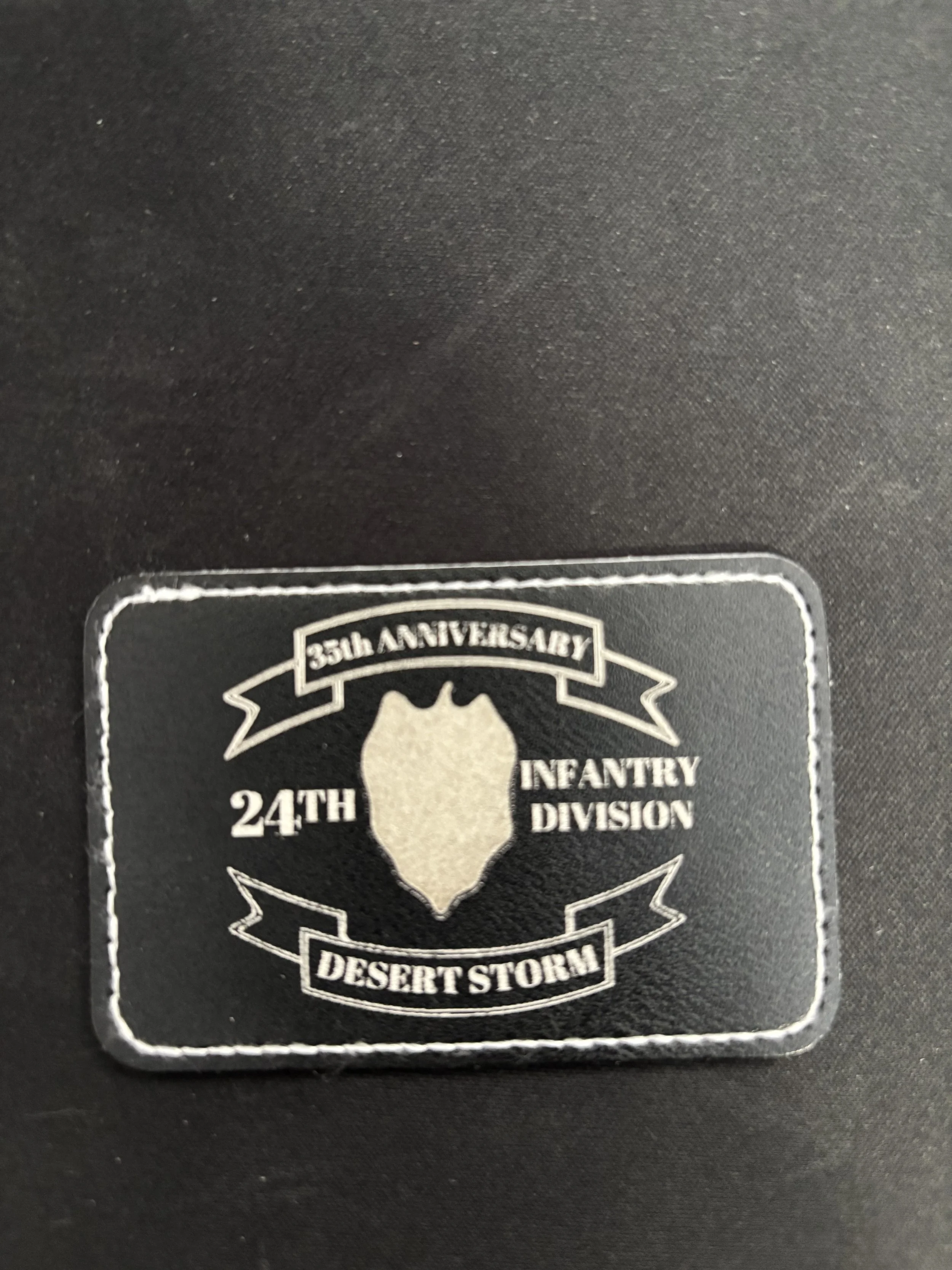 A patch celebrating the 35th anniversary of the 24th Infantry Division's Desert Storm division, featuring a lion's head emblem on a black background.