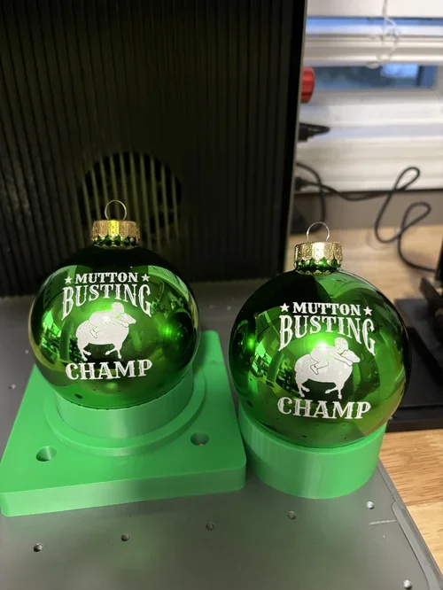 Engraved green ornaments personalized for a customer’s grandkids—featuring custom artwork and champion titles to celebrate their mutton busting wins.