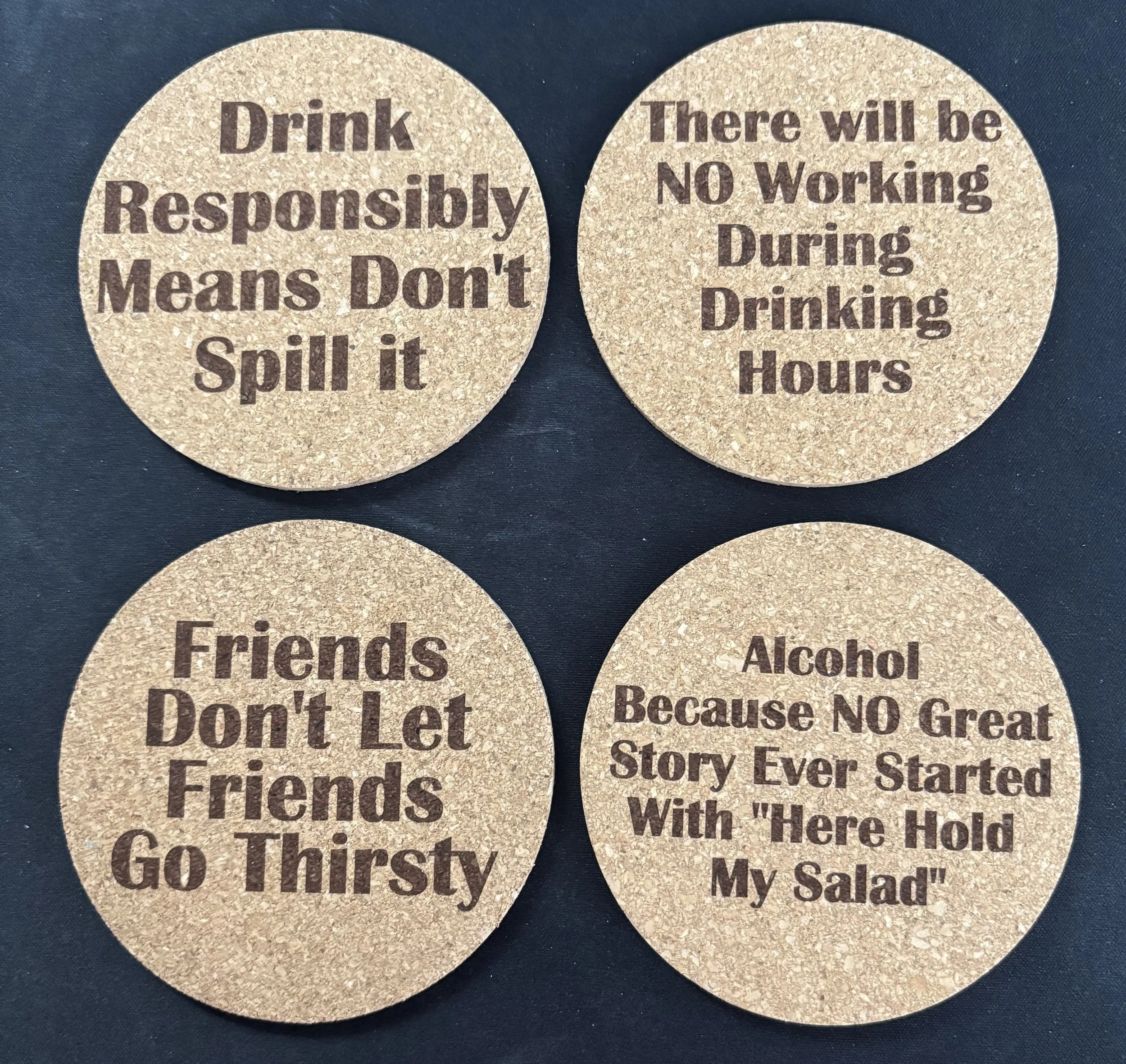 Four round coasters with humorous safety messages about drinking, friends, and alcohol.