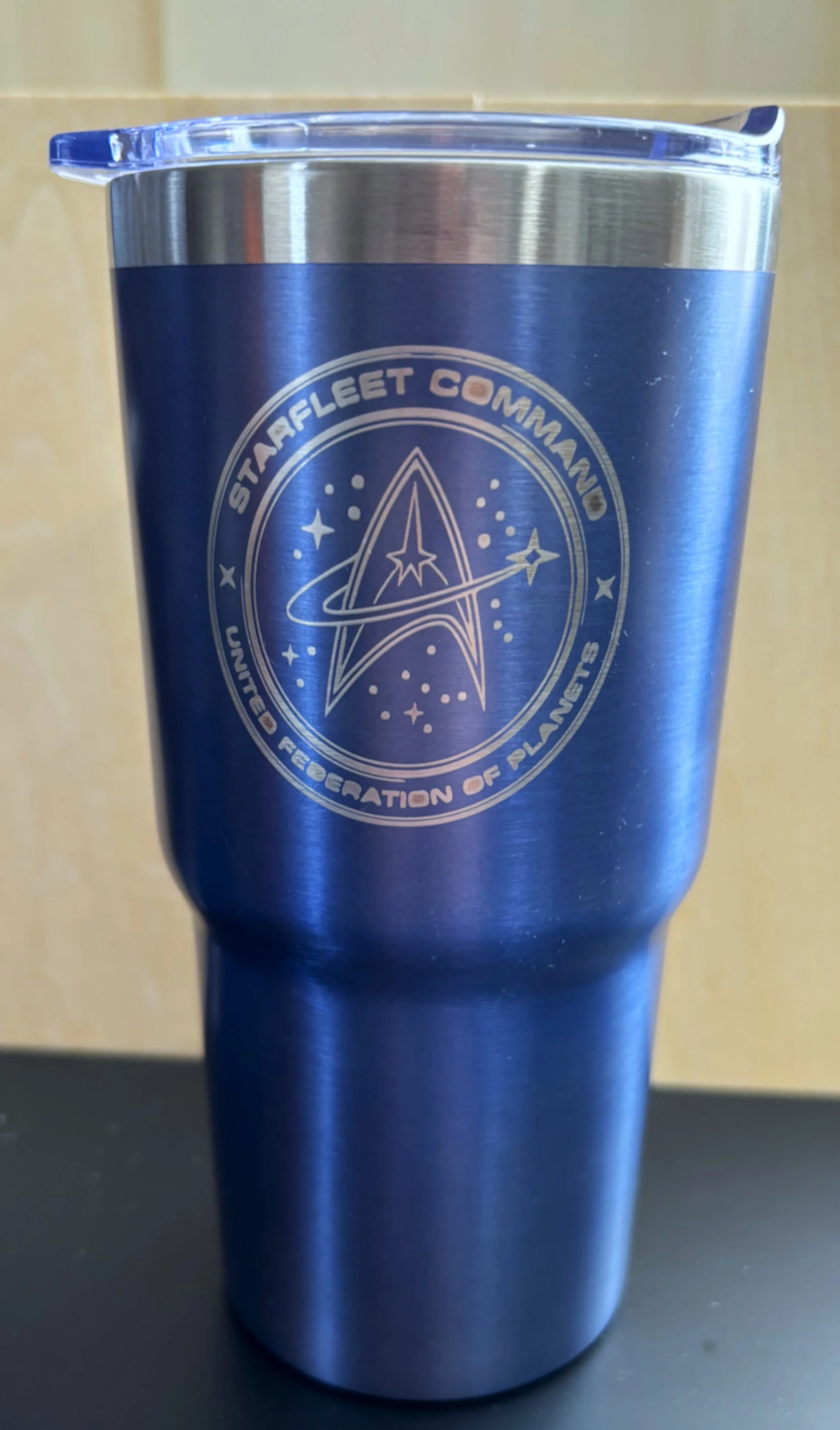 A blue stainless steel tumbler with a clear lid, featuring the Starfleet Command logo from Star Trek.