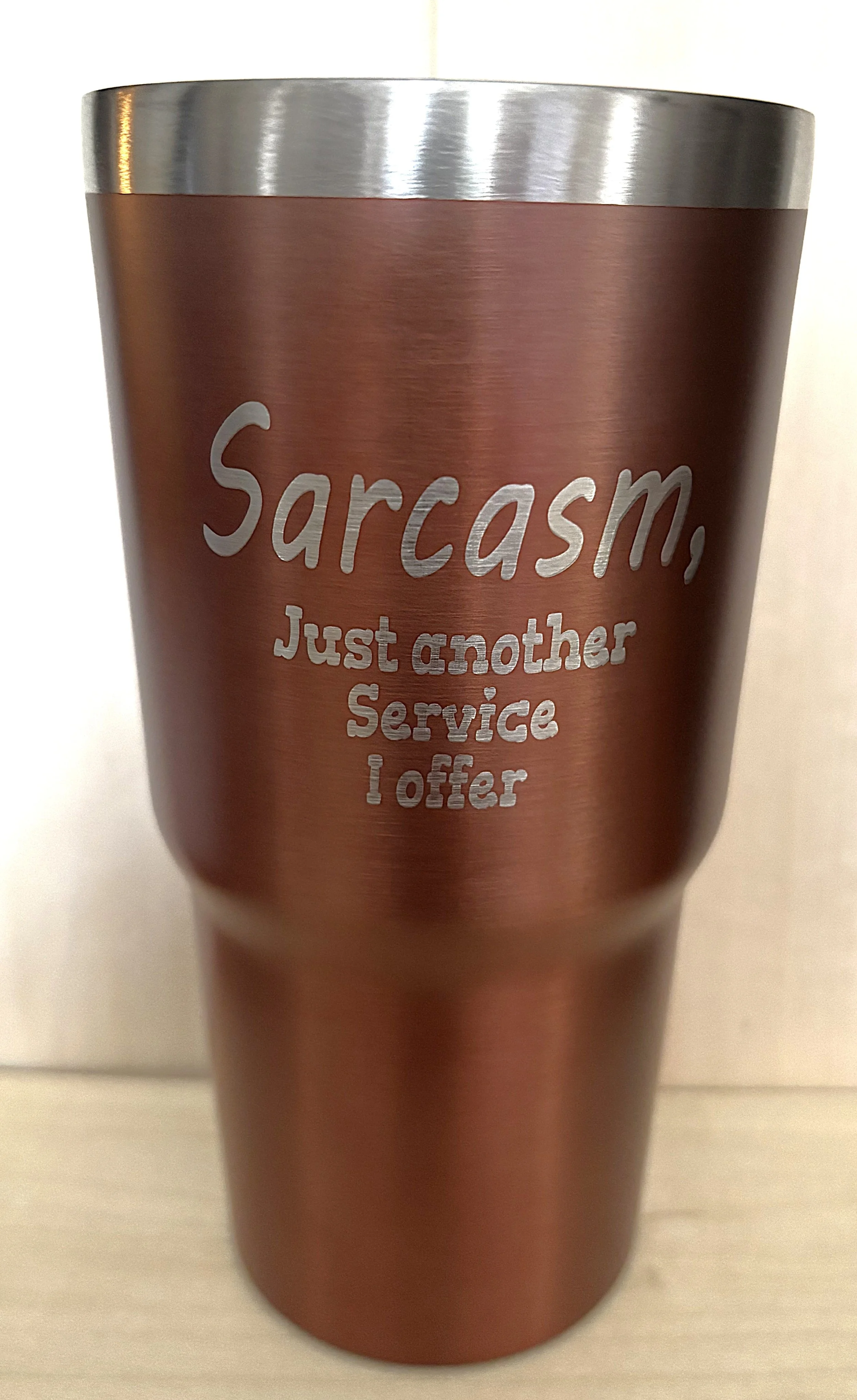 A metallic travel mug with the phrase 'Sarcasm, Just another Service I offer' engraved on it.