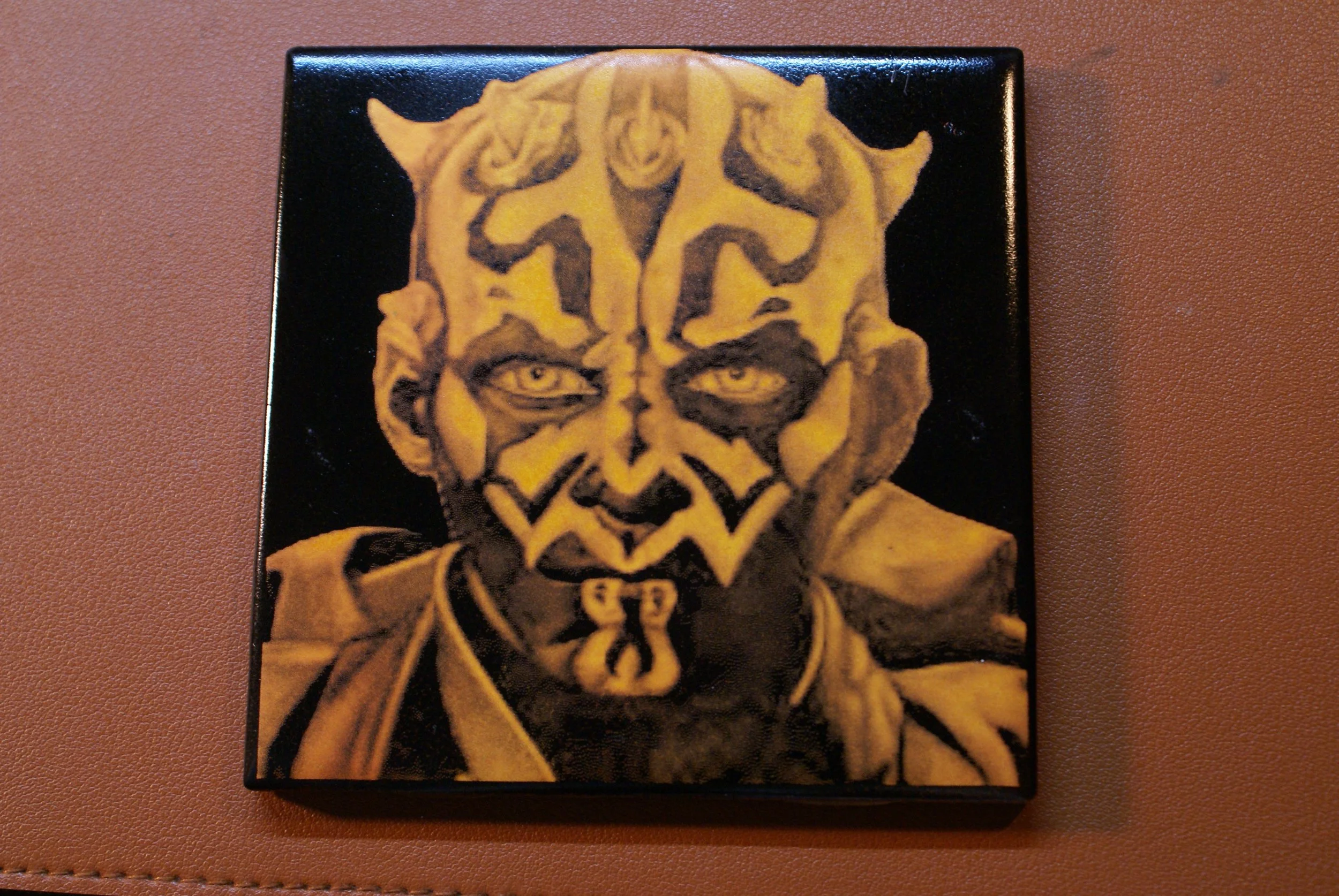 Painting of a humanoid figure with a mixture of human and alien features, wearing a yellow outfit and having an intricate face design with patterns and markings.