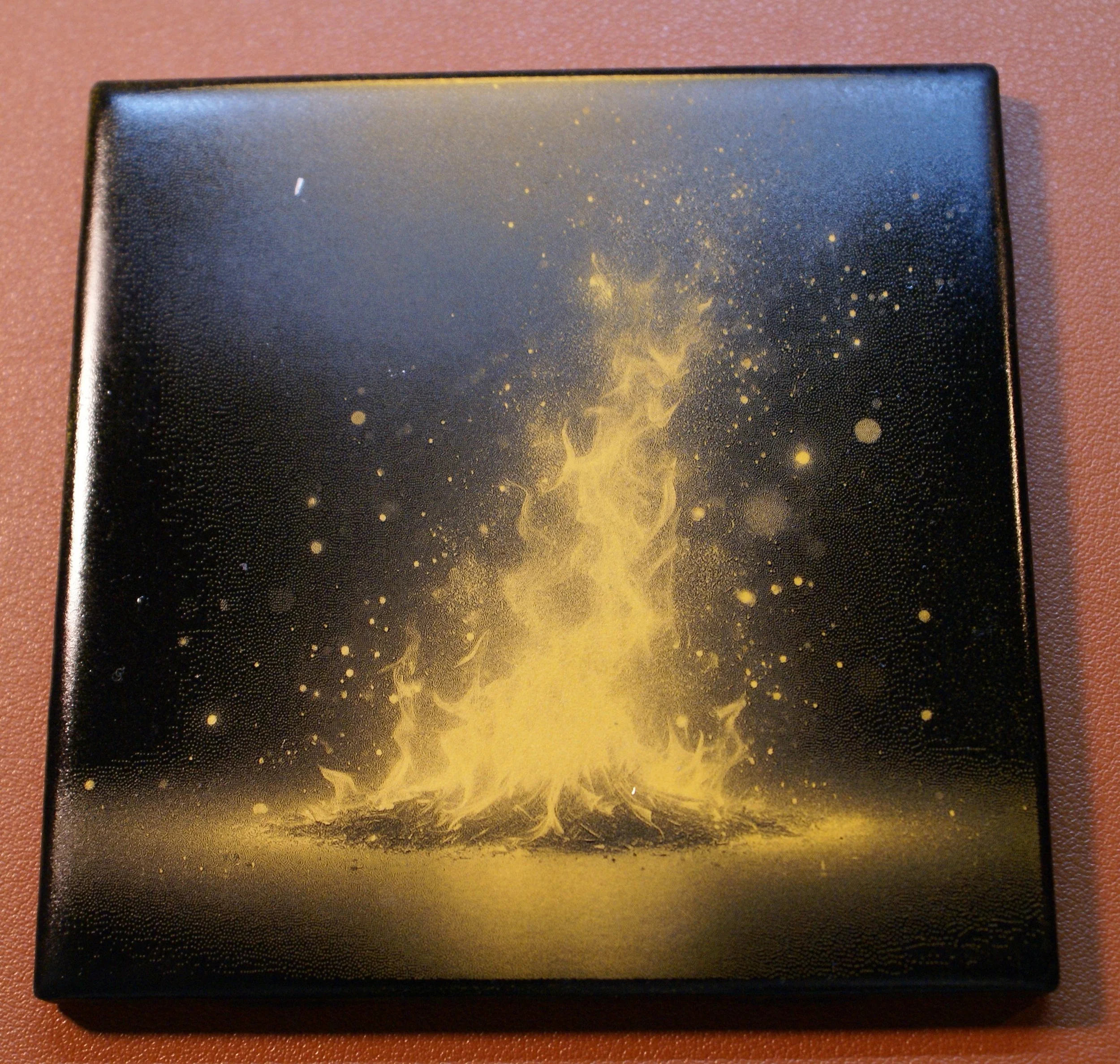 A black box with a yellow flame and sparks design on the lid.