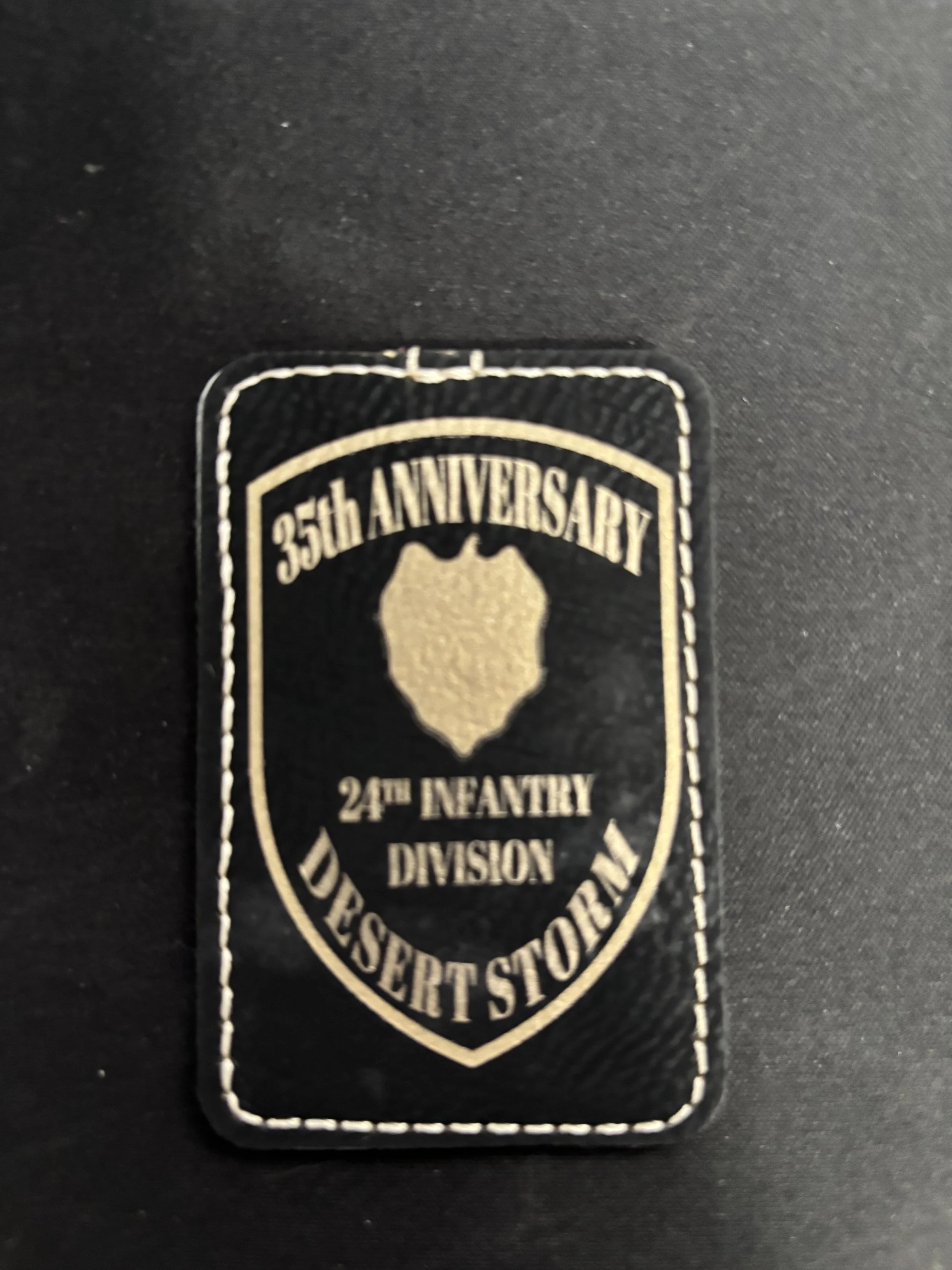 Black patch with gold emblem and text for the 35th Anniversary of the 24th Infantry Division Desert Storm.
