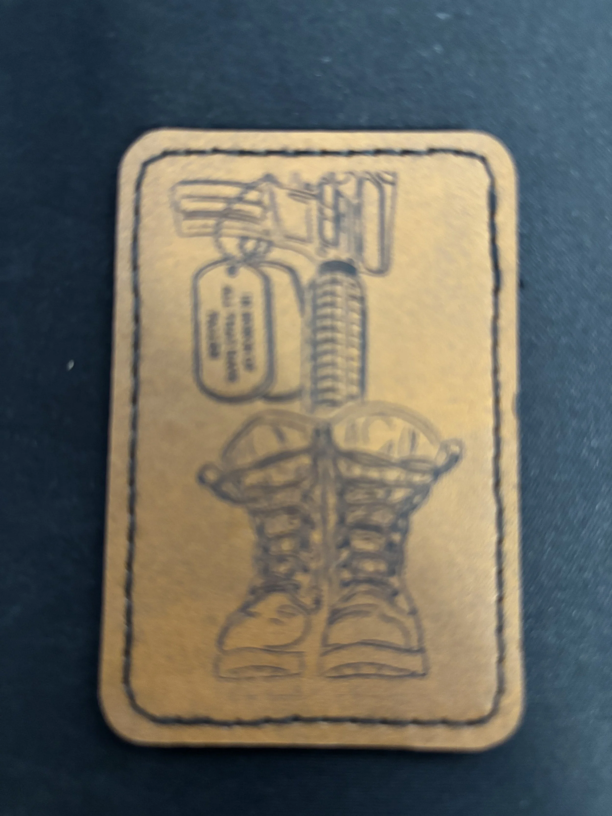 Blurred image of a card featuring a pair of boots, a shovel, and a small sign or tag, all outlined in a simple line drawing style.