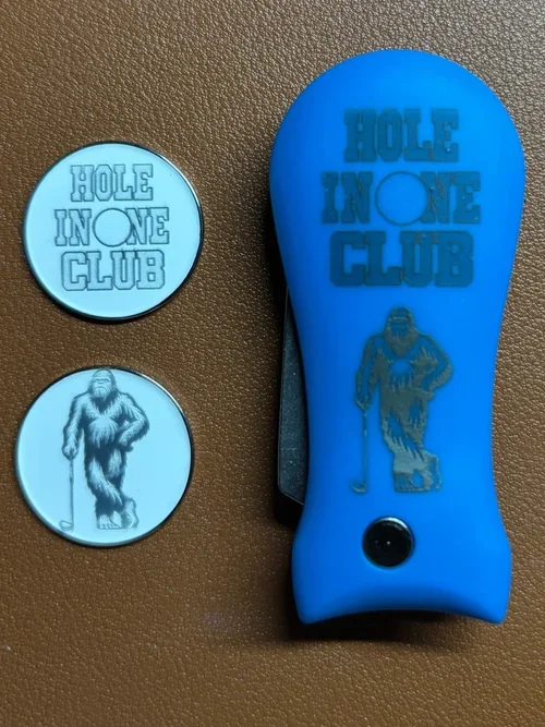 Custom golf accessory set commemorating a customer’s hole-in-one—engraved with bold artwork and matching tokens.