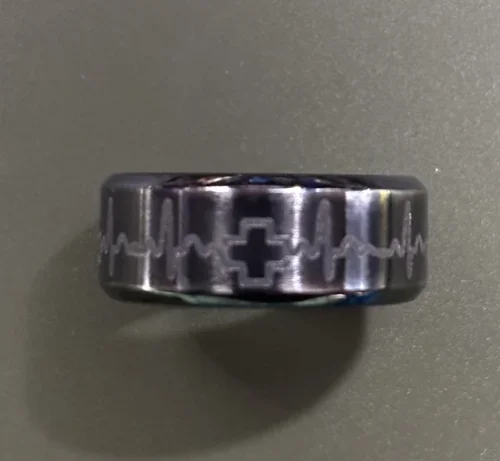 Sleek stainless steel ring featuring an engraved heartbeat (EKG) line and medical cross motif, finished with a polished, modern look—perfect for healthcare professionals or anyone inspired by strength, care, and resilience.