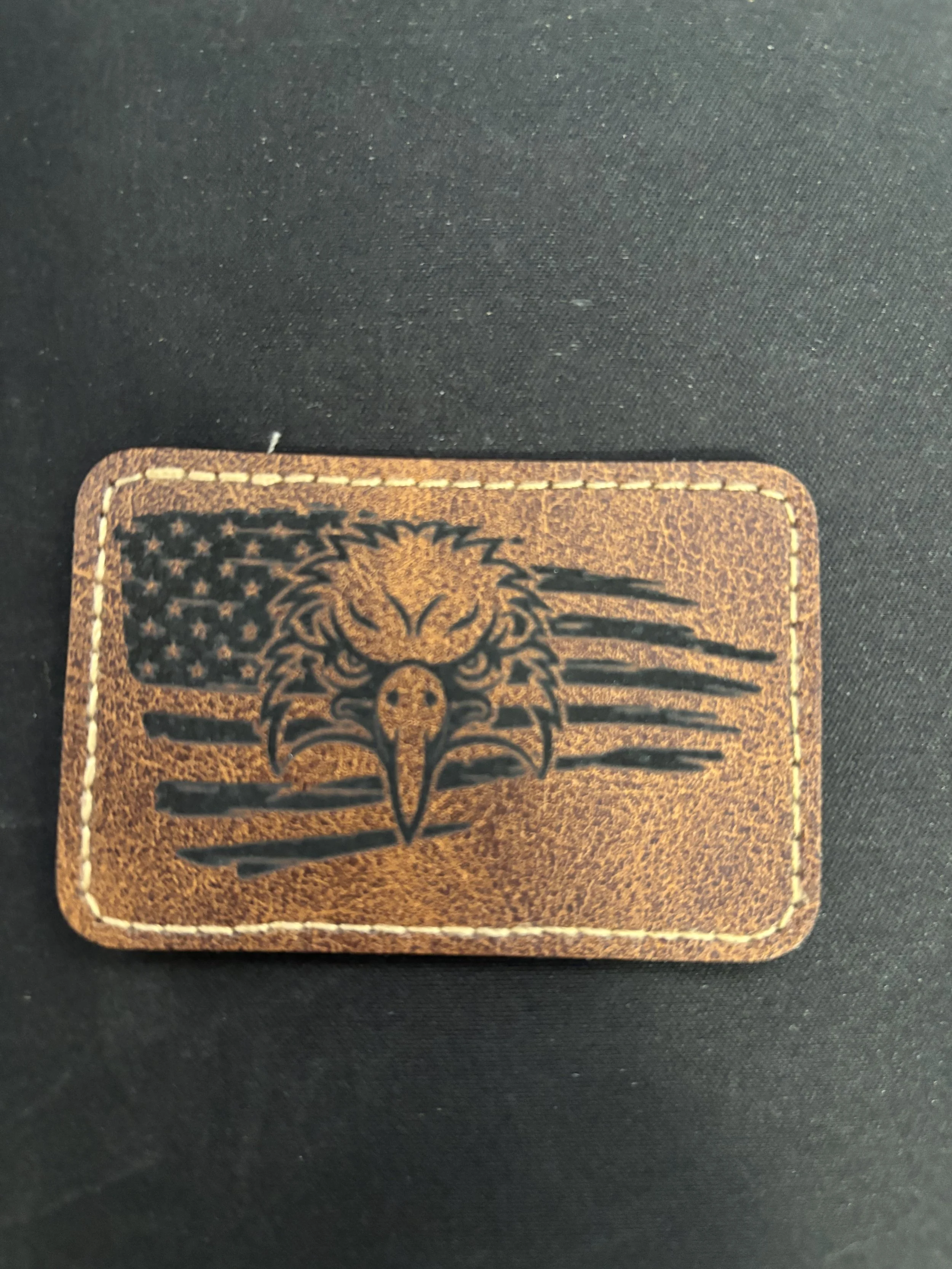 Leather patch featuring a stylized eagle with an American flag background.