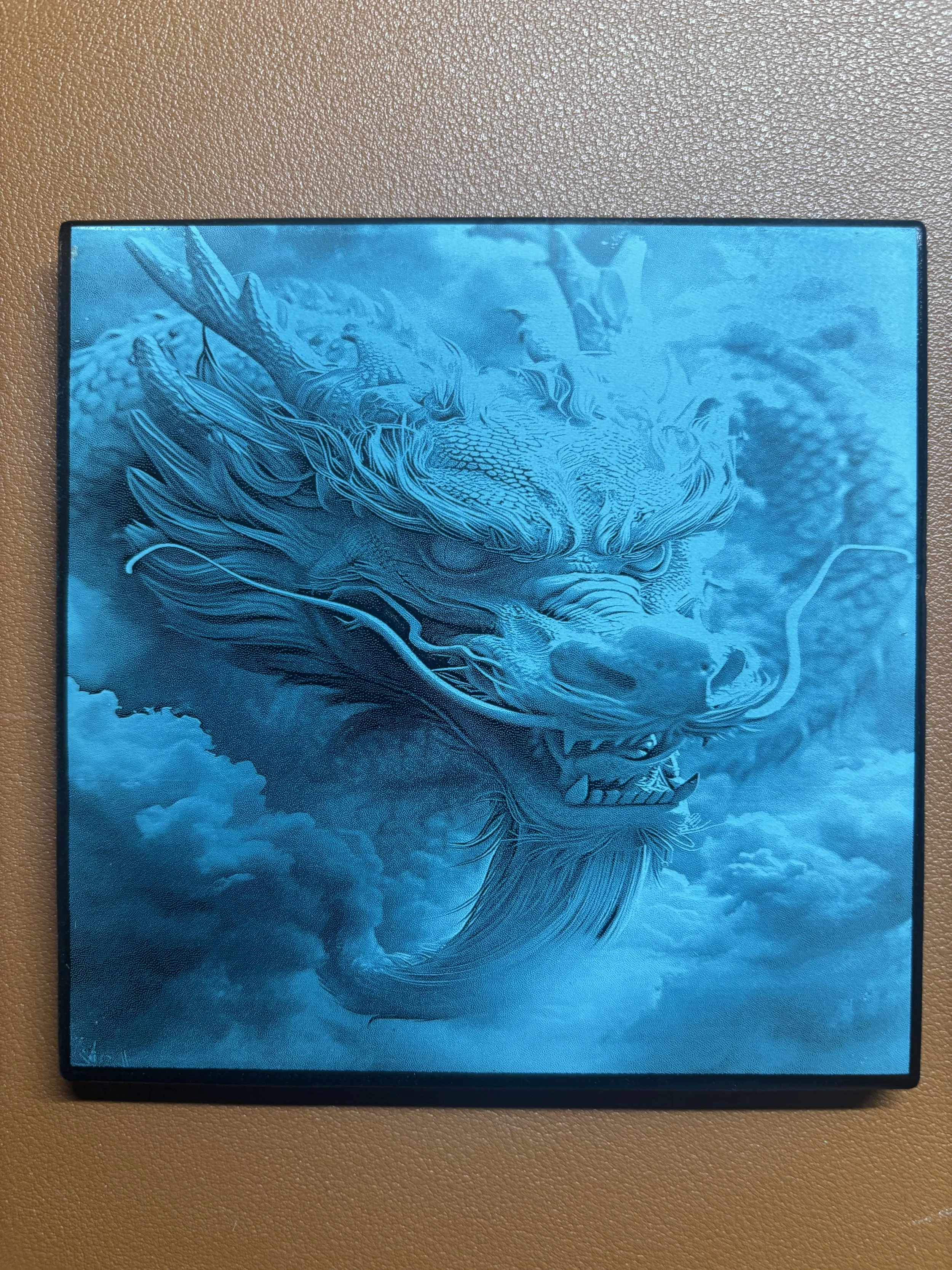A blue-toned illustration of a fierce dragon with detailed scales, sharp teeth, and flowing mane set against a cloudy sky background.