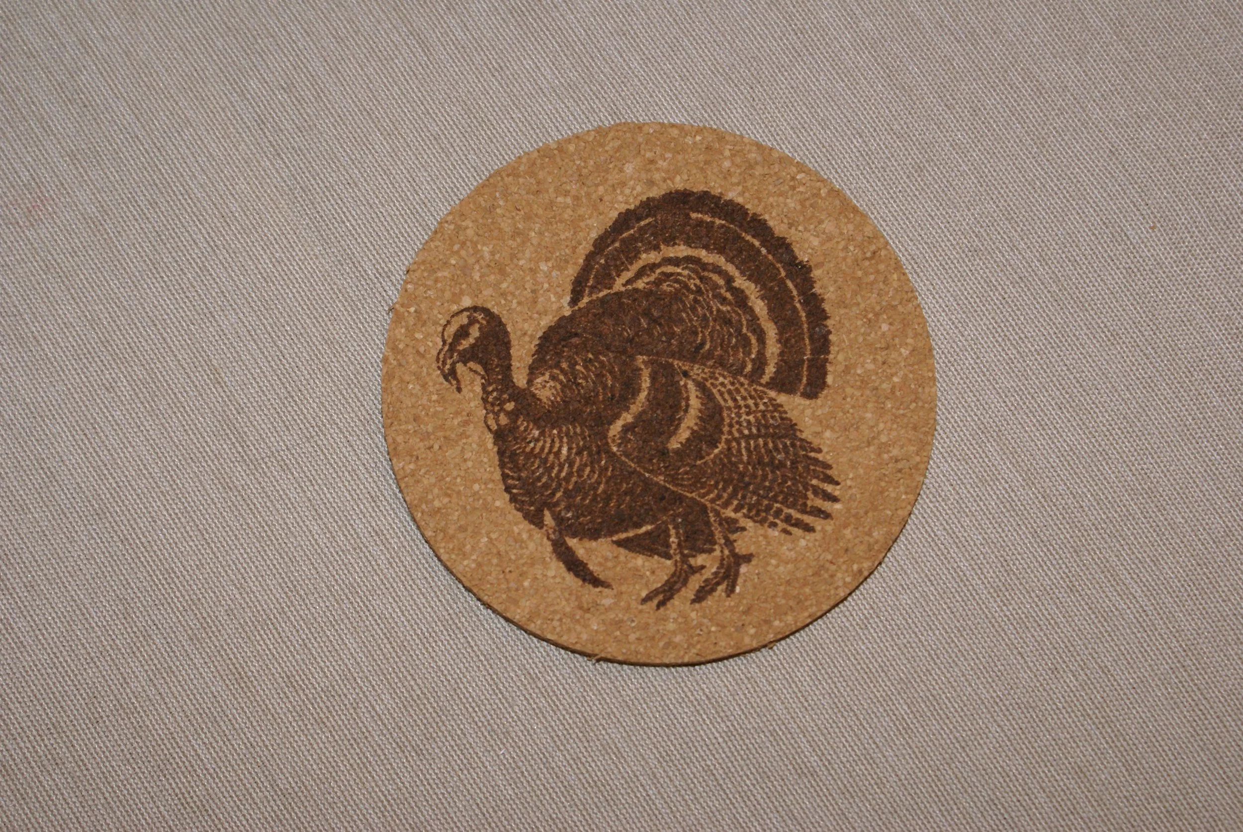 A cork coaster featuring a detailed illustration of a turkey.