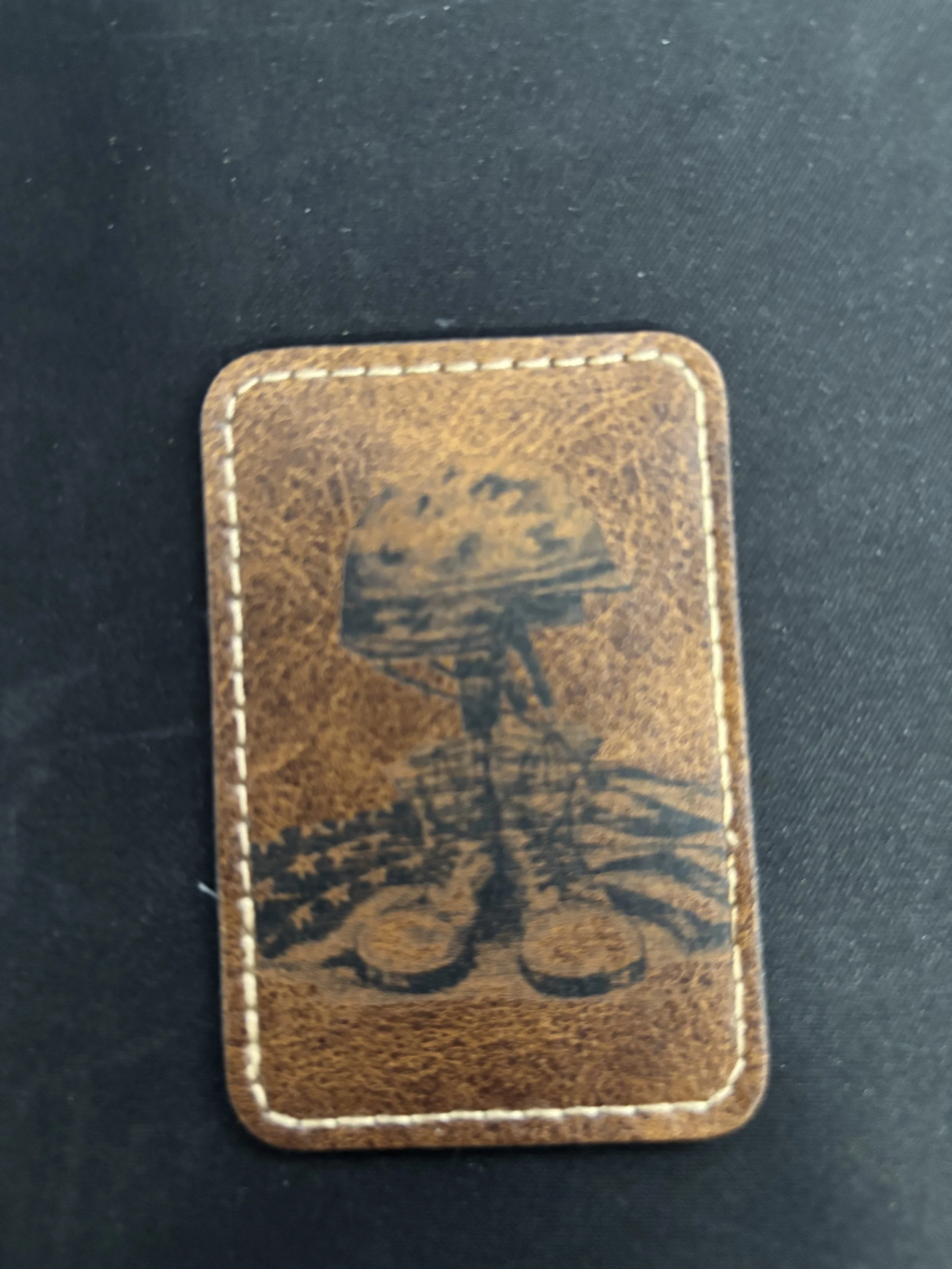 Leather patch with a printed design of a mushroom with a cloudy sky and a landscape in the background.