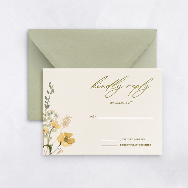 A white RSVP card with floral illustrations and calligraphy, accompanied by a green envelope on a white surface.