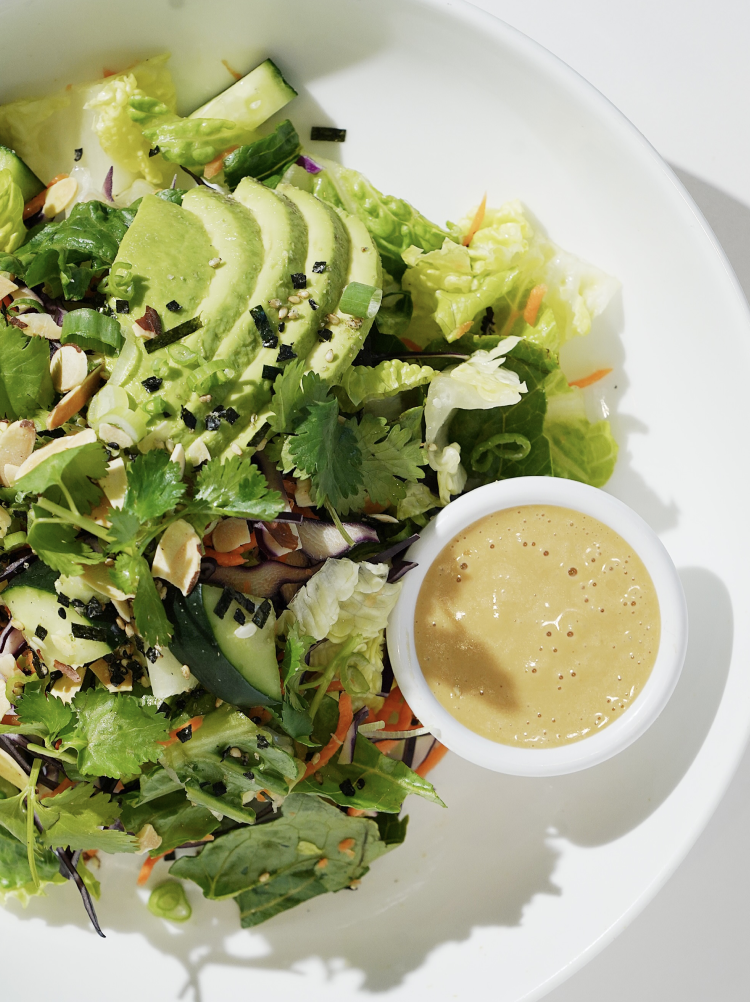 Ginger Sesame Salad  A bright, refreshing mix of crisp romaine and cabbage layered with radish, carrots, cucumbers, scallions, creamy avocado, and fresh cilantro. Finished with crunchy almonds, savory nori furikake, and a vibrant sesame-miso dressing