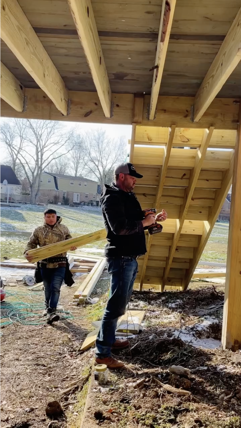 Deck Craft Owner pictured with a drill under a new staircase Deck Craft repaired in Cottonwood, Franklin, TN