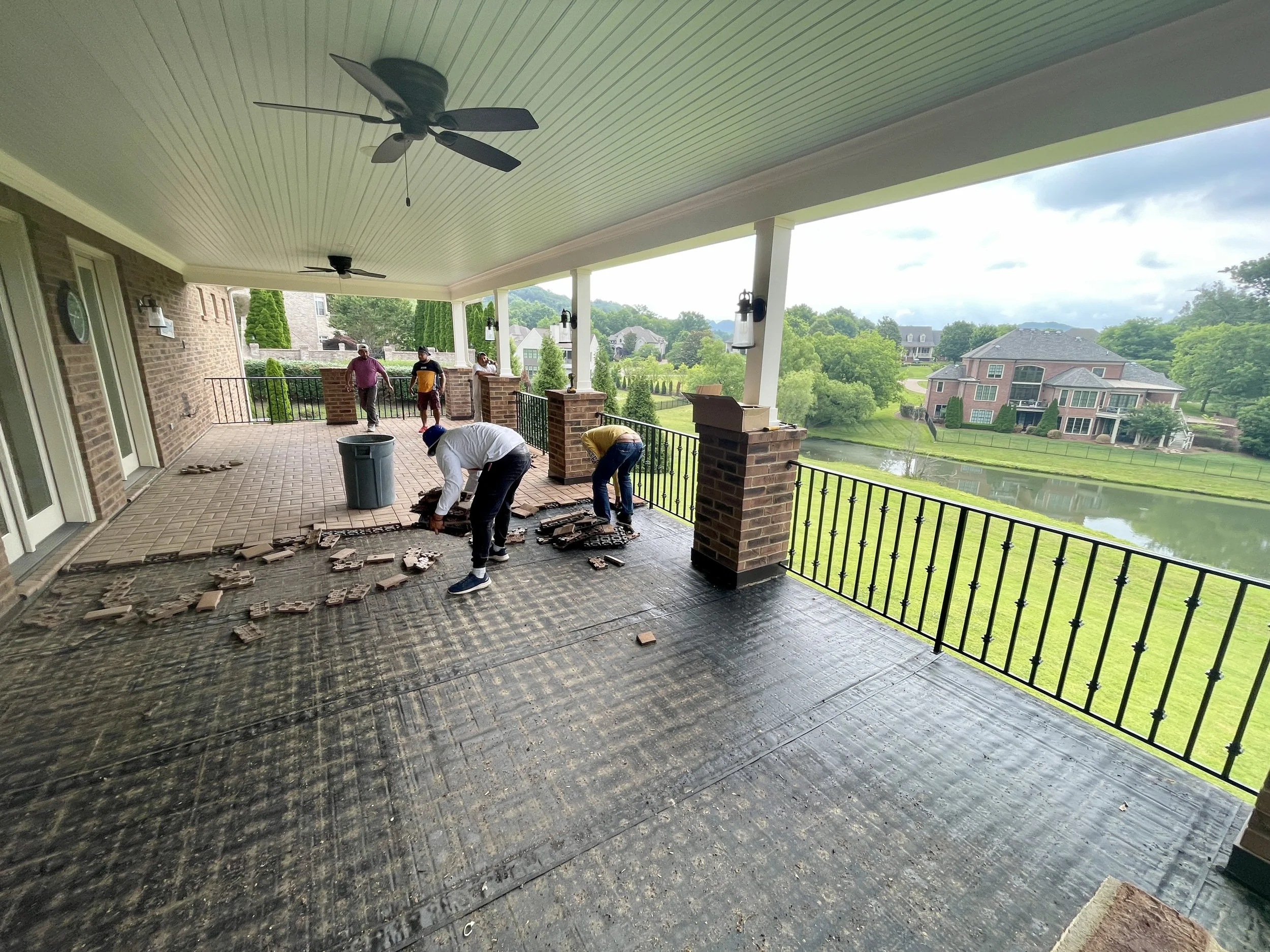 Before picture showcasing a large covered deck with old brick pavers in Legends Ridge, Franklin, Tennessee