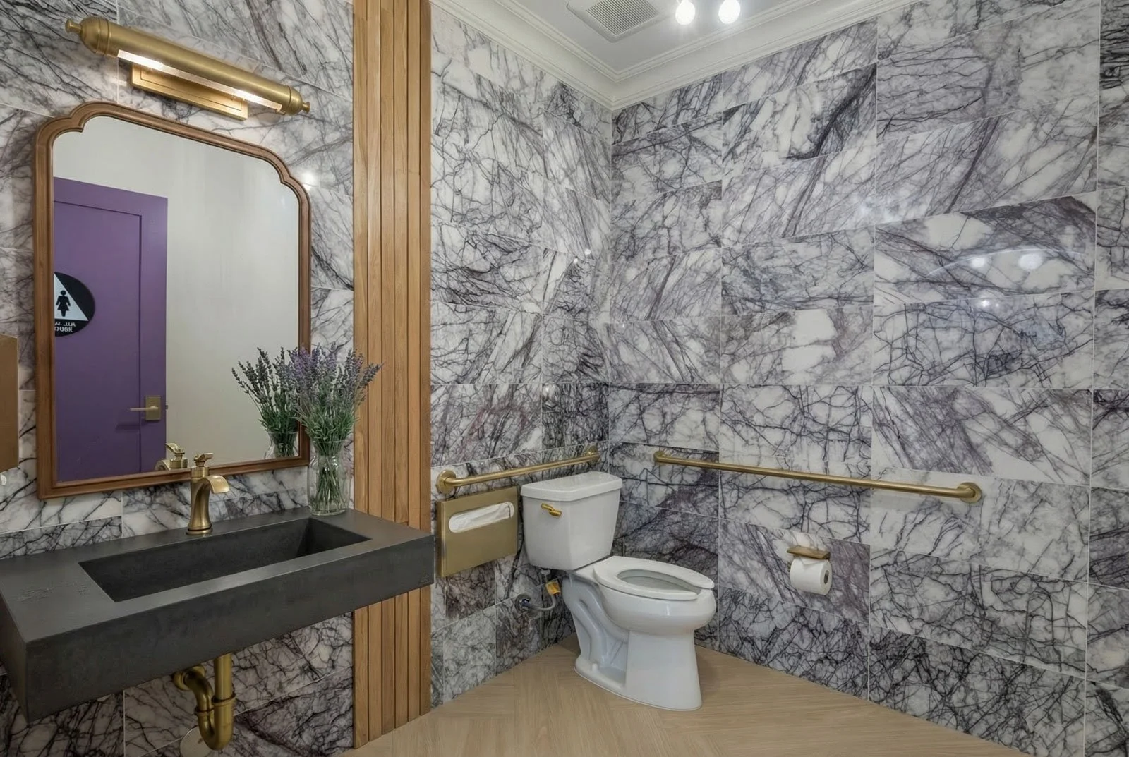 ADA bathroom private practice dental office champagne bronze grab bars gold toilet seat cover concrete wall hung sink luxury marble wall tile certified designer