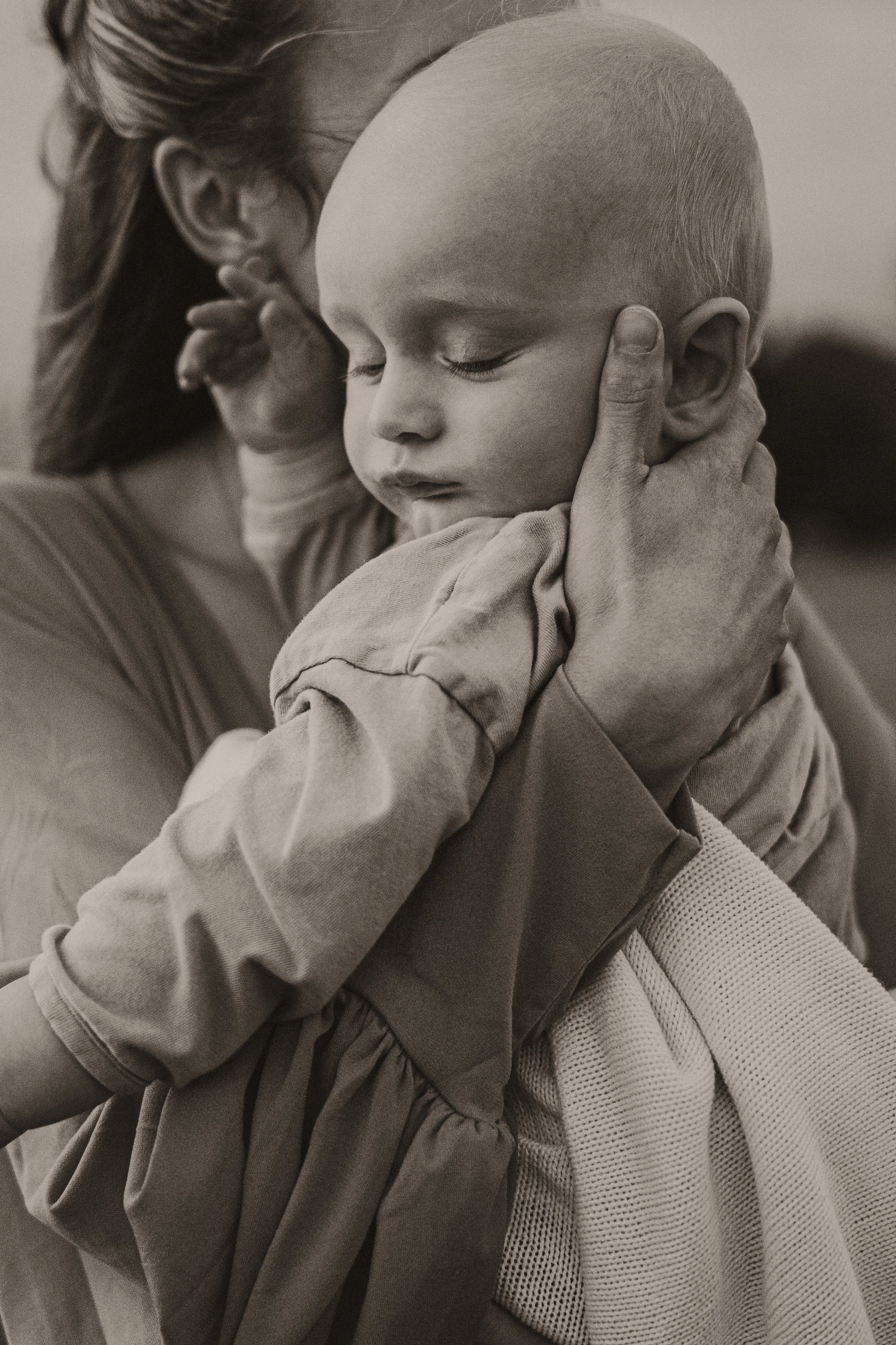 Ein Kind wird in den Armen gehalten, beide mit geschlossenen Augen.