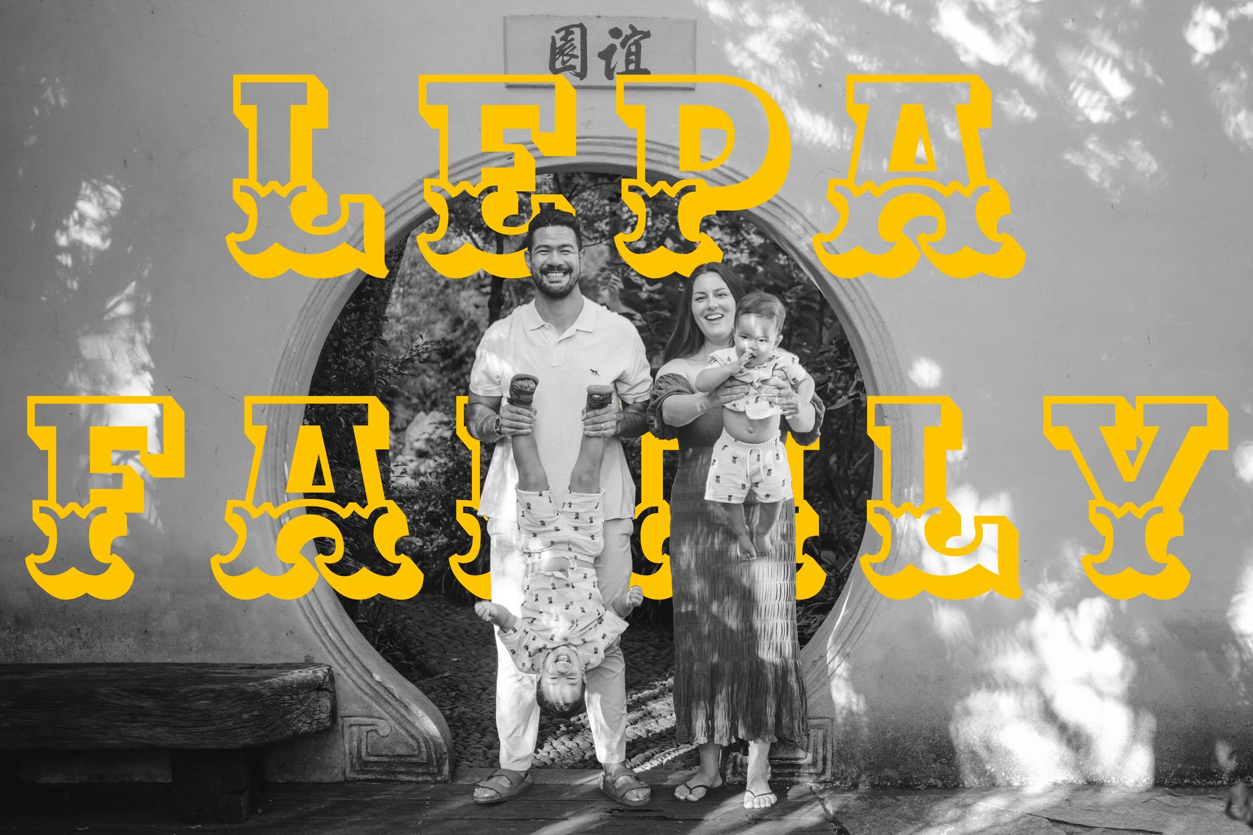 Black and white family photo in front of a decorative door with the text "LEPA FAMILY" in large yellow stylized letters overlaying the image.