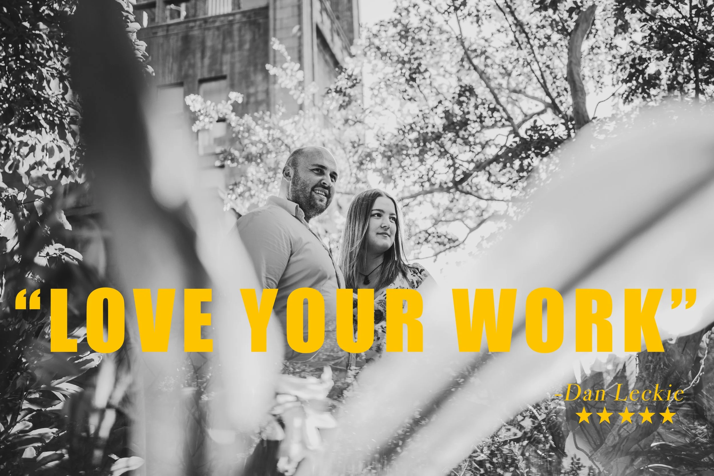 Black and white photo of a man and woman standing outdoors among trees, with a quote in bold yellow text that reads, "LOVE YOUR WORK," and smaller yellow text underneath that says "- Dan Leckie" with five yellow stars.