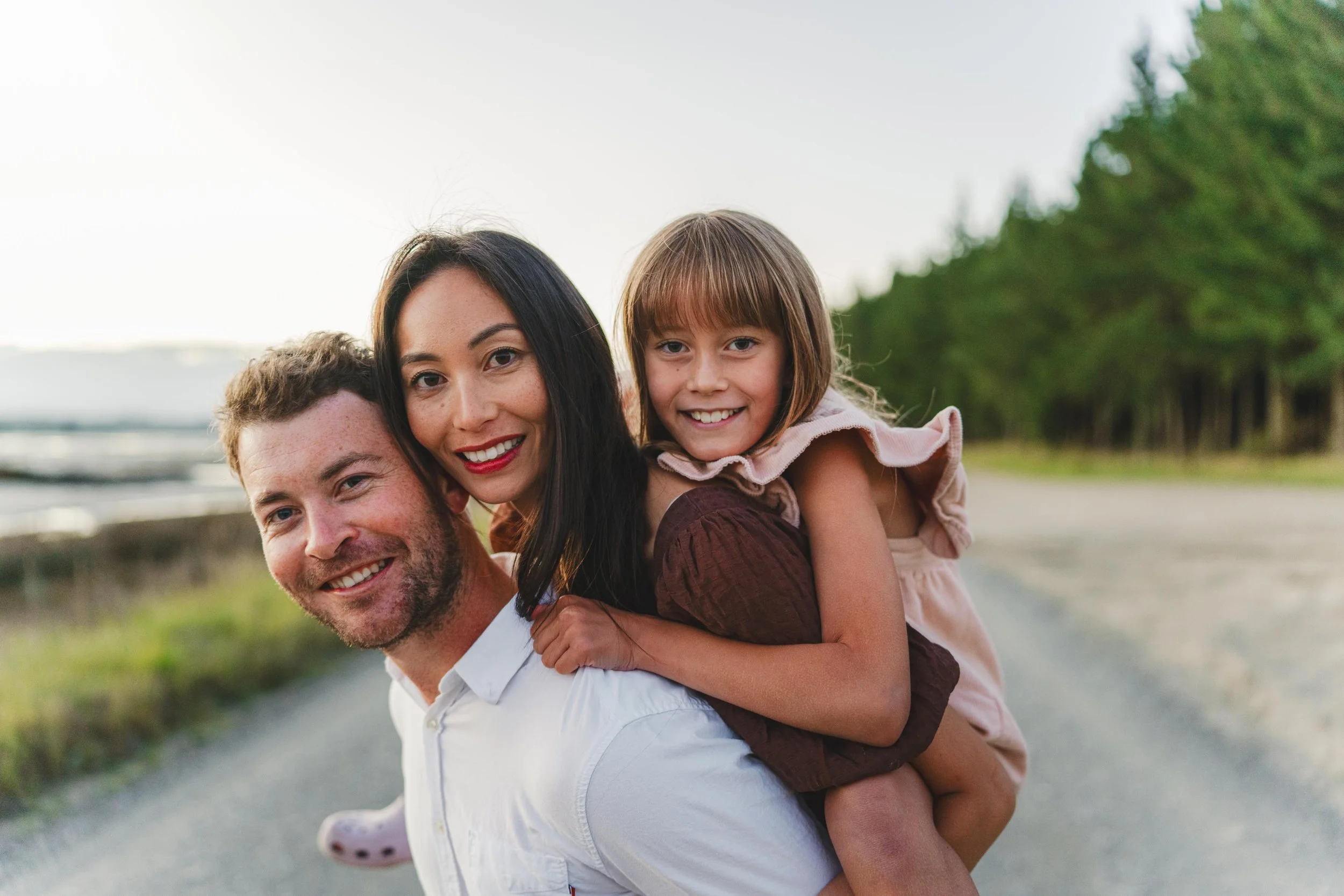 Happy family enjoying outdoor walk on a dirt road with forest in the background