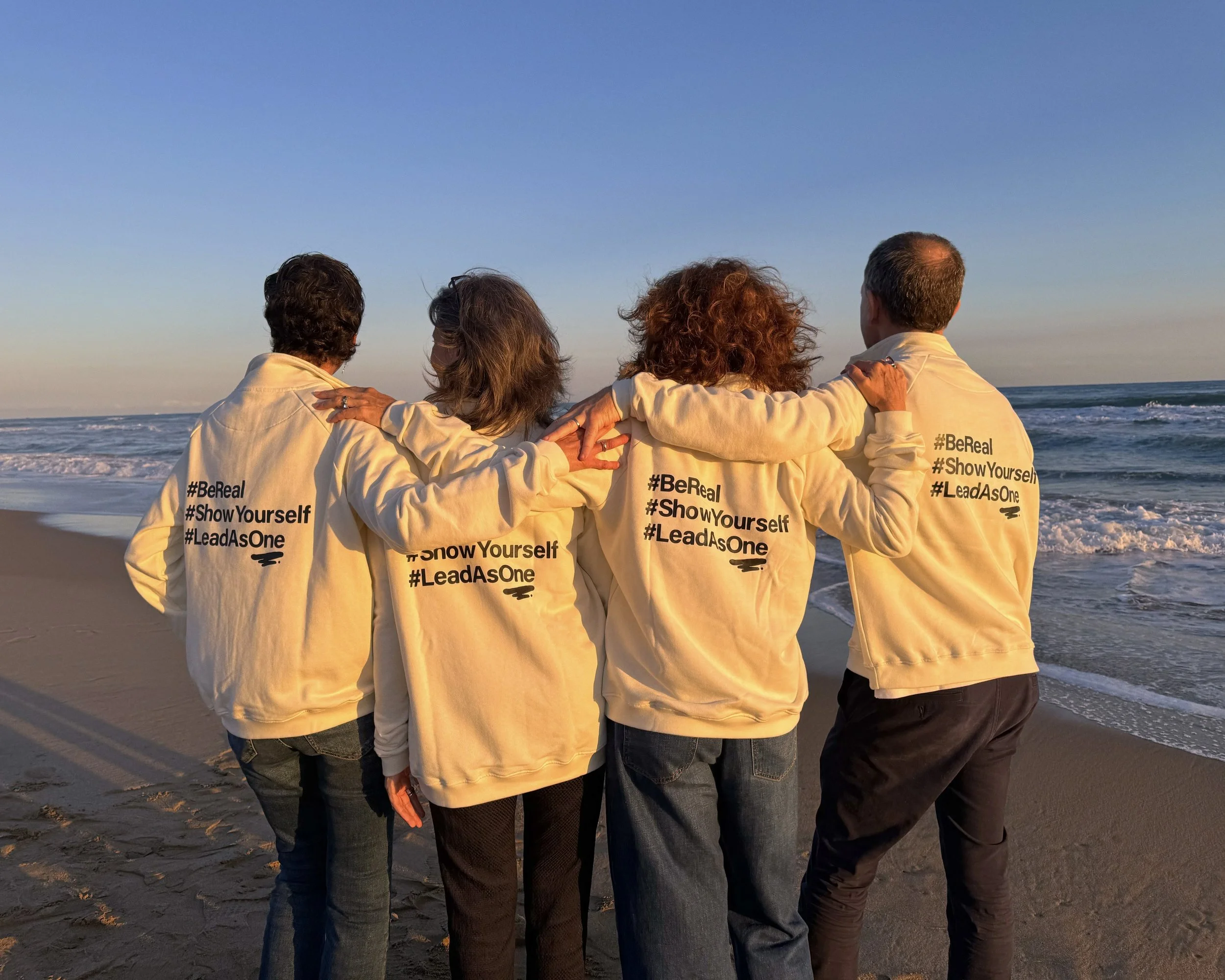 Equipo de trabajo de espaldas en una playa