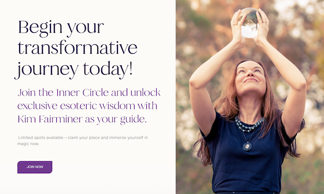 A woman outdoors in a park holding a crystal ball above her head and looking up at it in sunlight with autumn trees in the background.