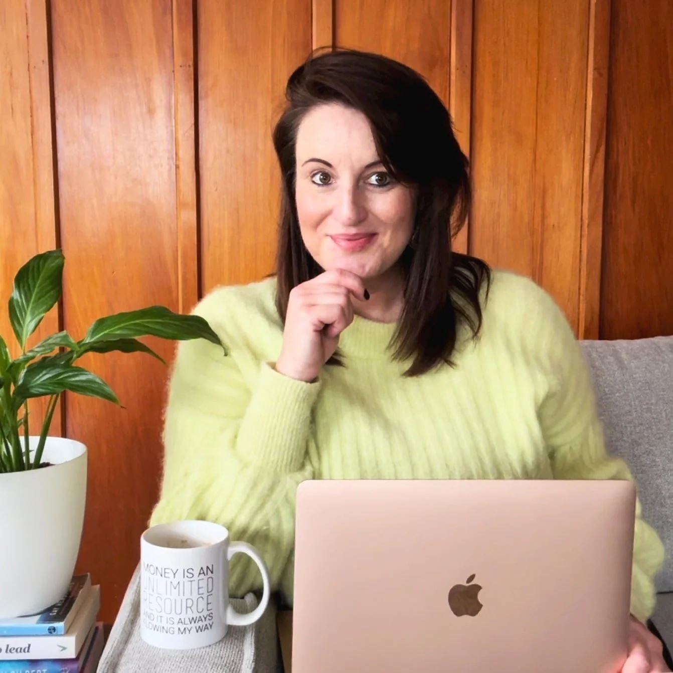 Squarespace website designer wearing a lime coloured jumper and her Apple Macbook Air is on her lap.
