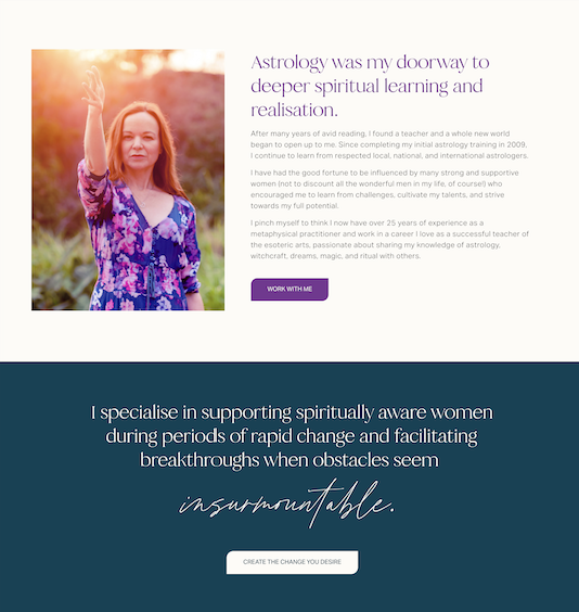 A woman with shoulder-length red hair wearing a purple floral dress, standing outdoors in a green park, raising her right arm, with sunlight filtering through trees in the background.