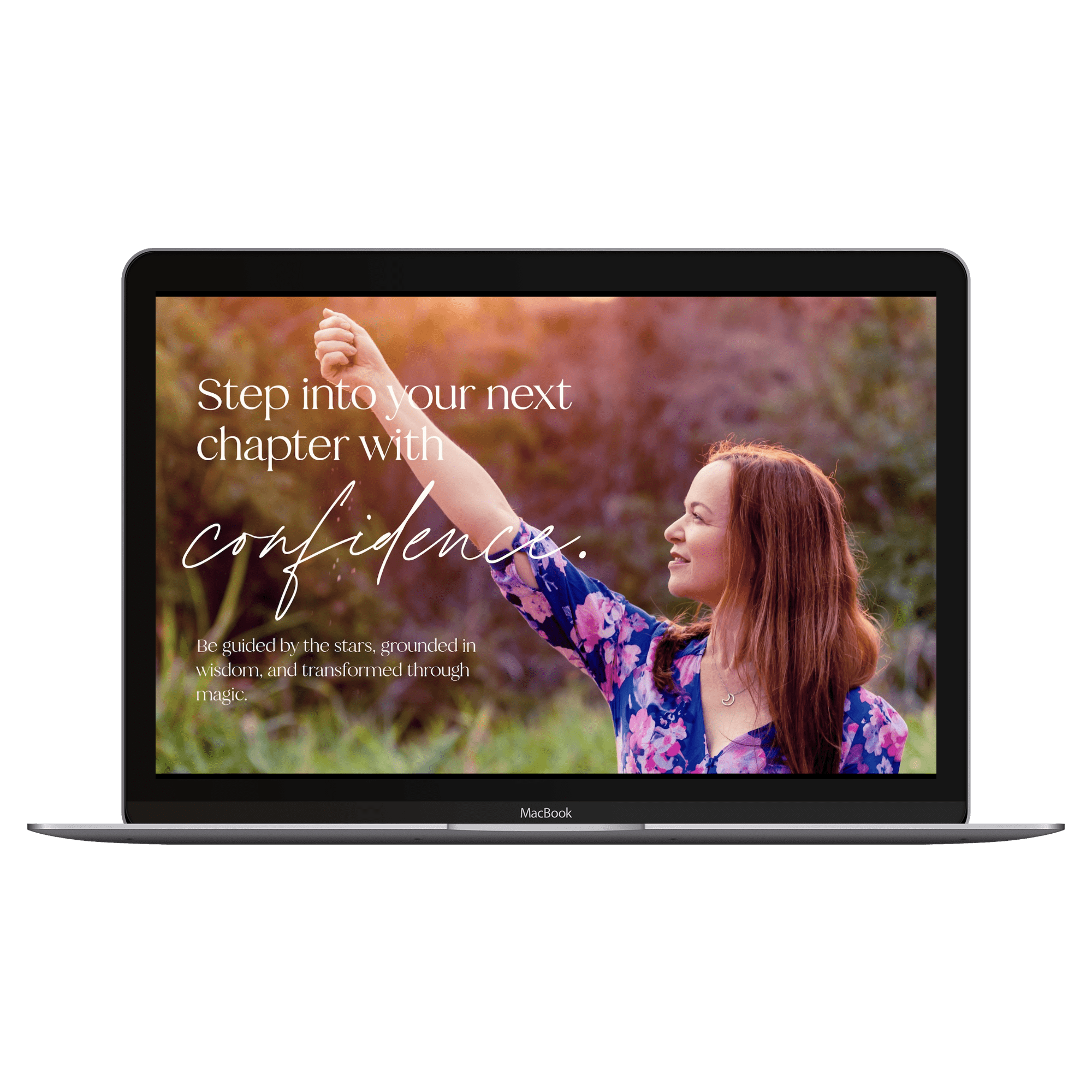 Woman with long red hair, wearing a blue floral dress, smiling and raising her arm outdoors during sunset with trees in the background.