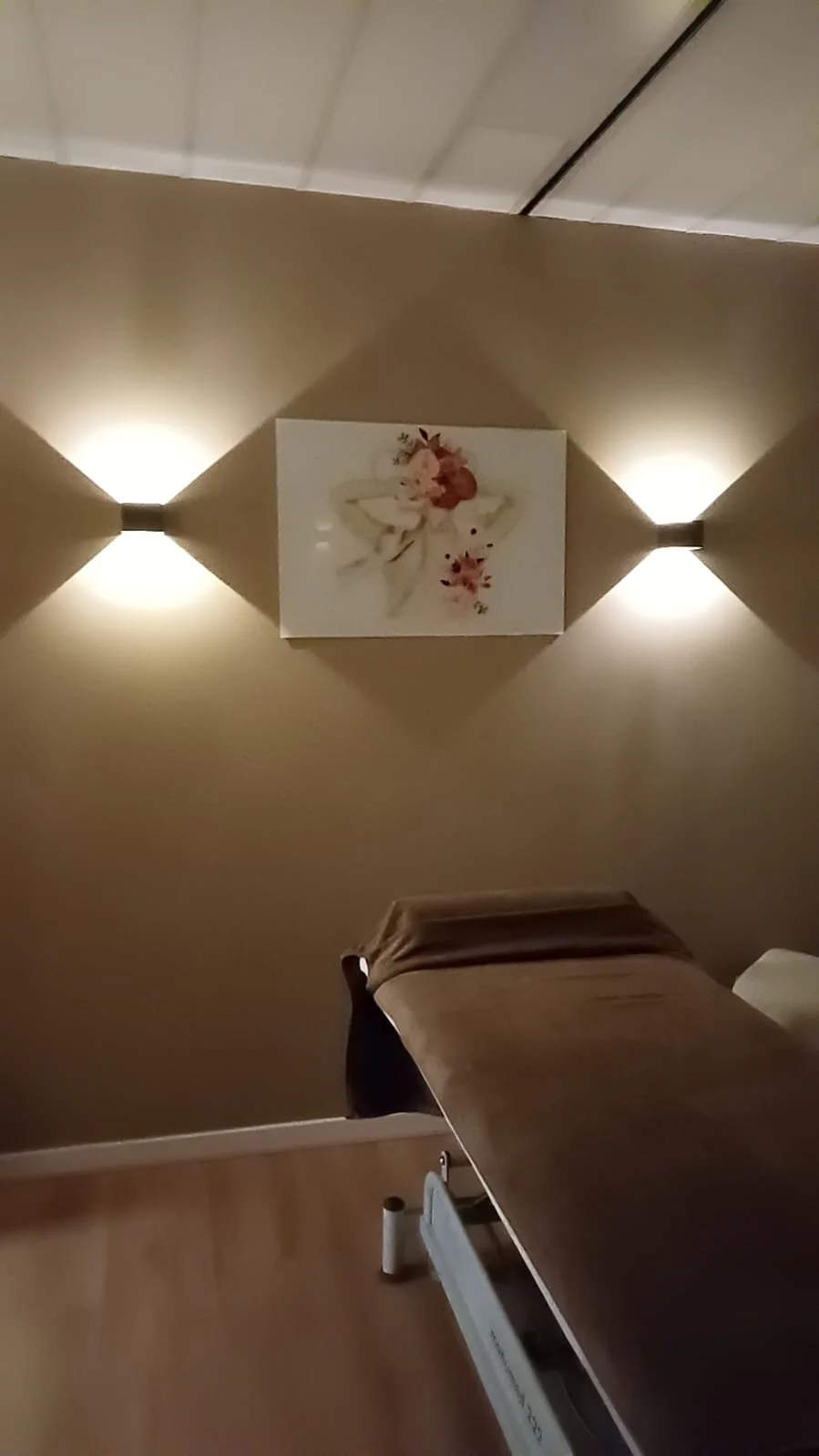 Een steriliseringswasbakje op een tafel met een gele boog erover, omringd door kussens en kaarsen op een vensterbank.