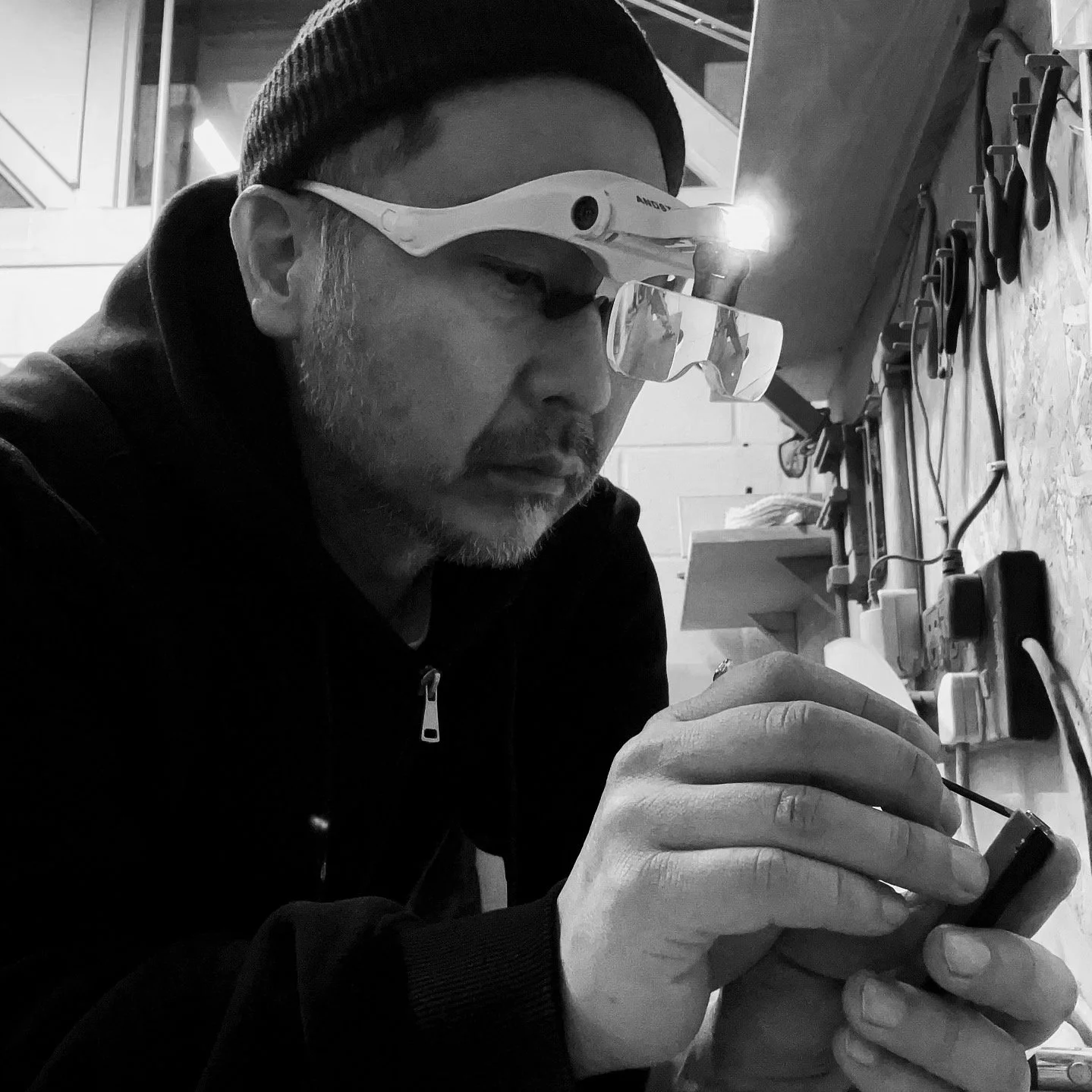 Person wearing magnifying glasses working on crafting peice