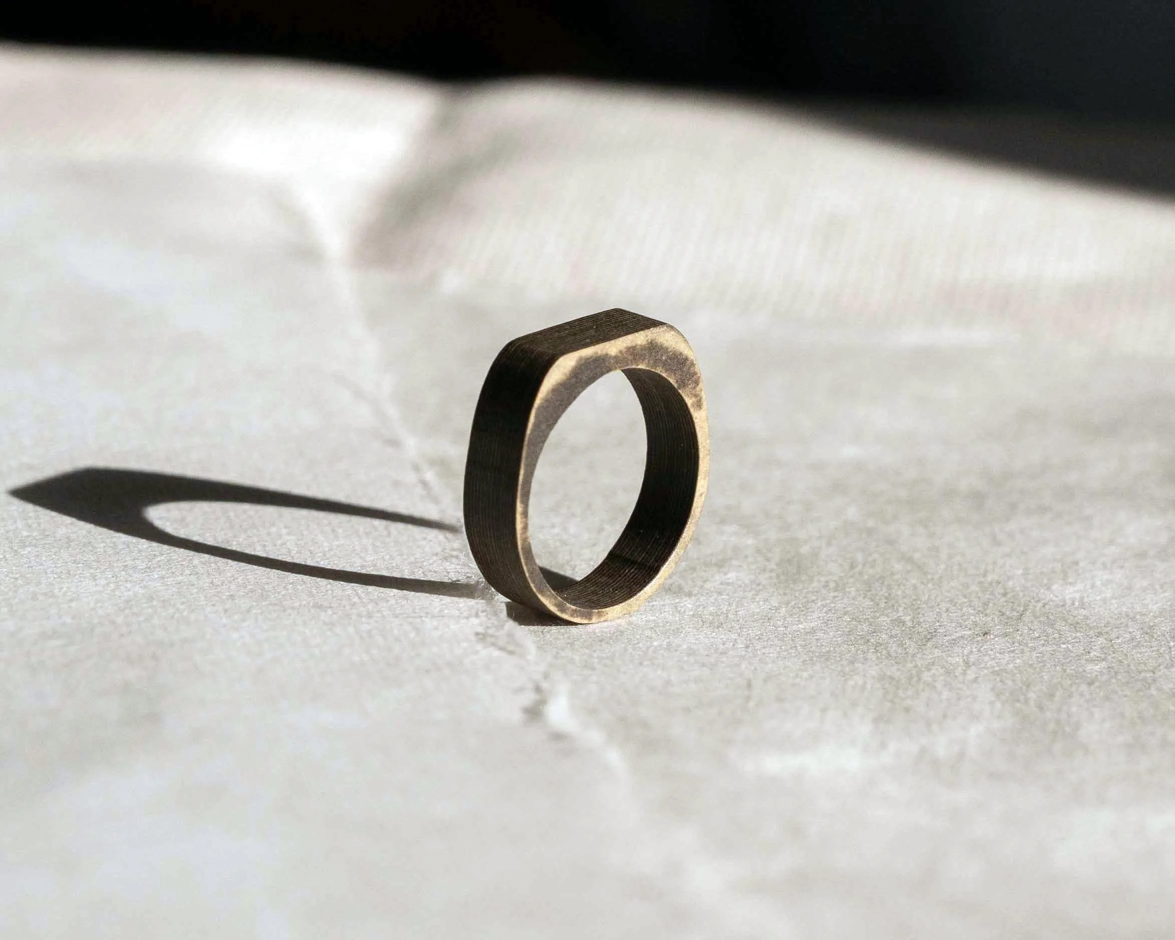 A sculpted ring for daily wear, Japanese minimalist, handmade in London from compressed paper composite. Light on the hand and smooth against the skin, it brings a dense matte surface and quiet character distinct from plastic, resin, or metal.
