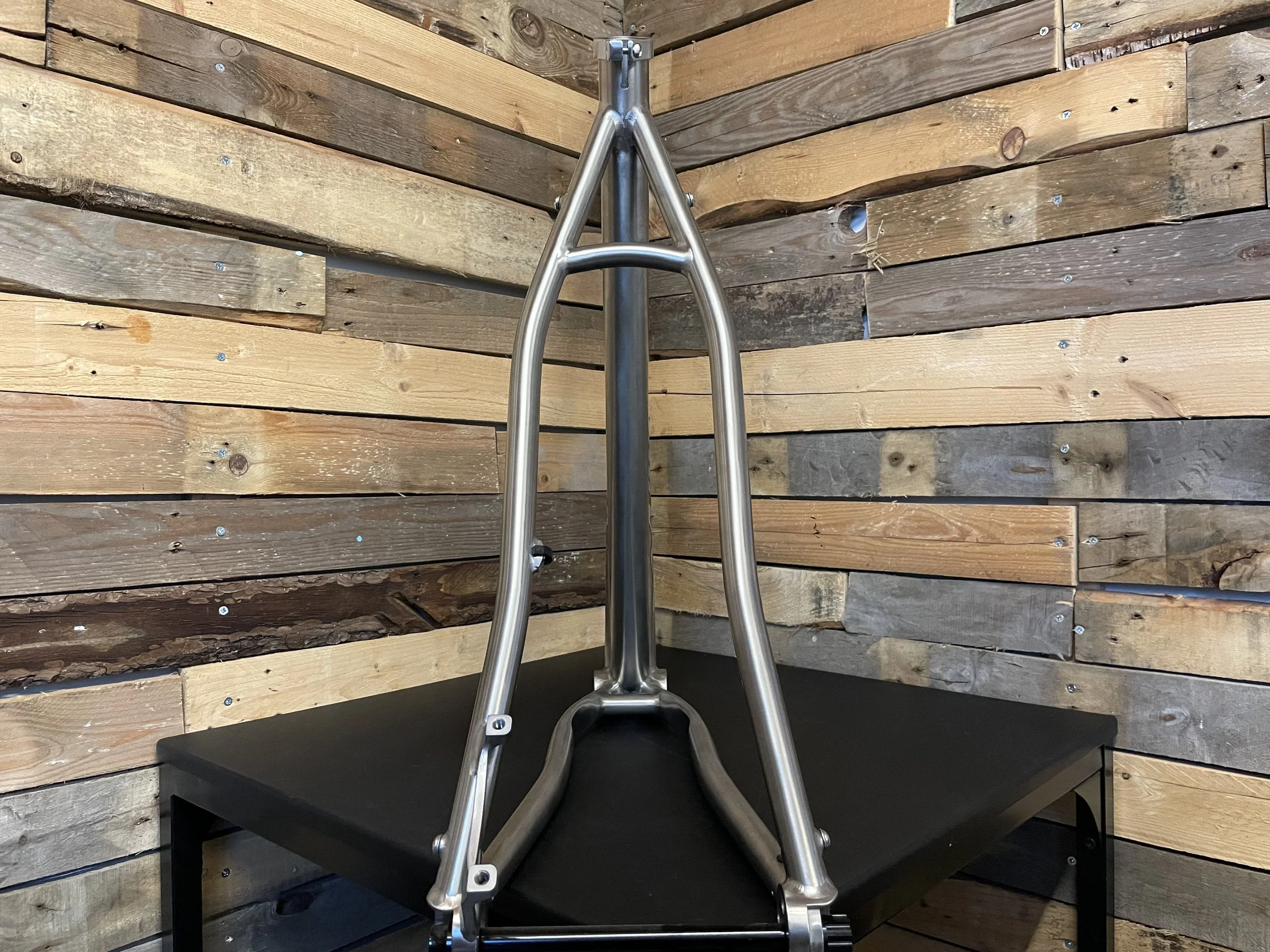 Bicycle frame on black table with wooden background