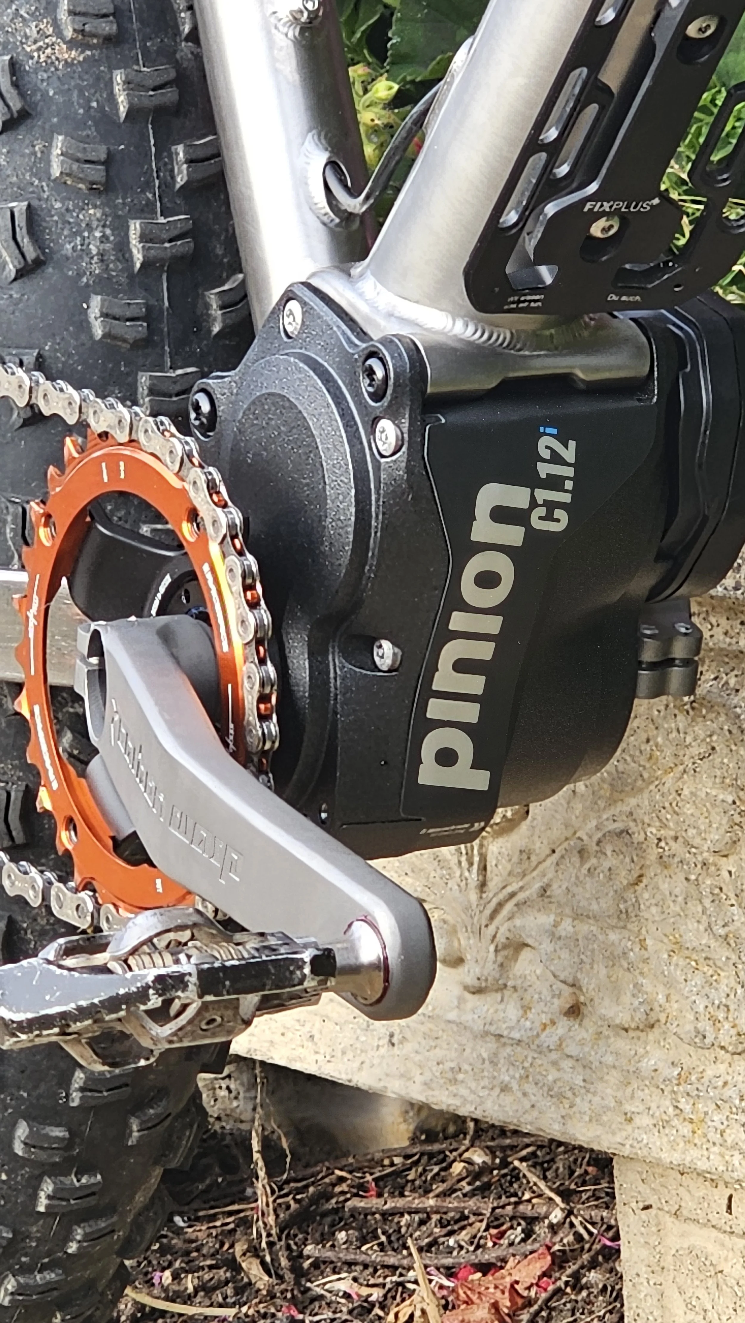 Close-up of a Panasonic G1.12 electric mountain bike motor and part of the chainring on a black tire.