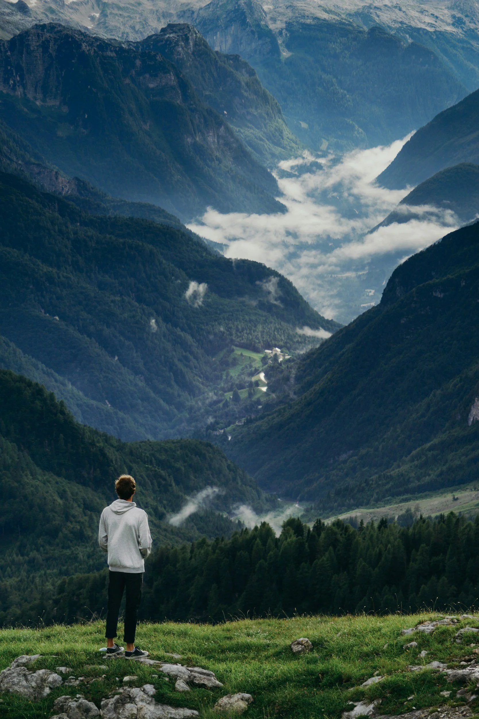 A boy looks out across a wide mountain landscape, symbolizing growth, discovery, and the larger world opened through reading.