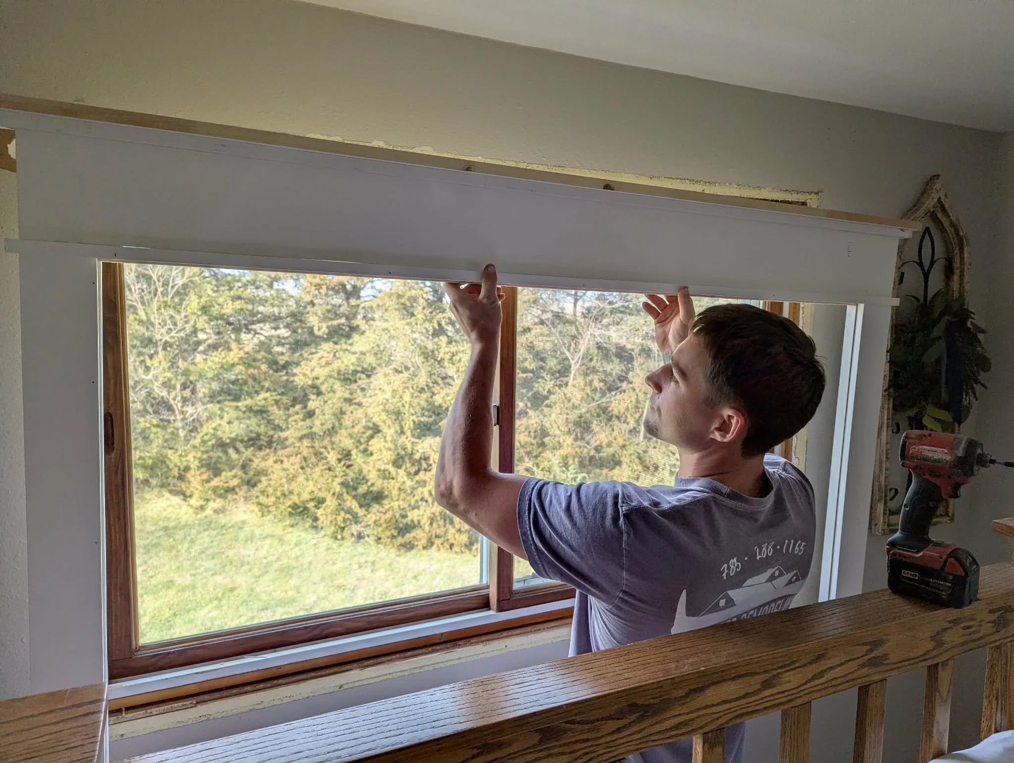 Man installing a window trim assembly.