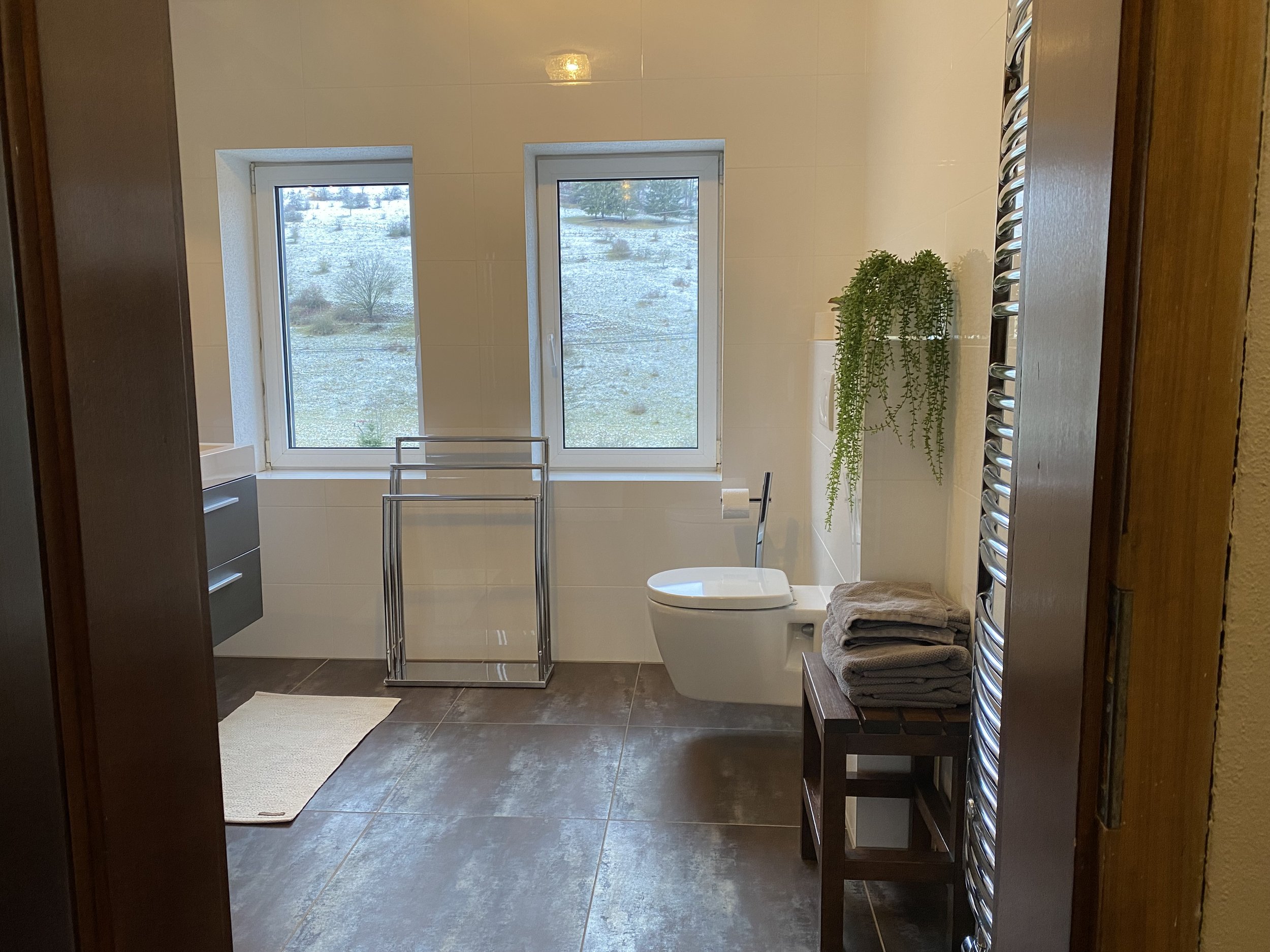 luxuriöses Badezimmer mit herrlichem Blick auf Berge und Wiesen.