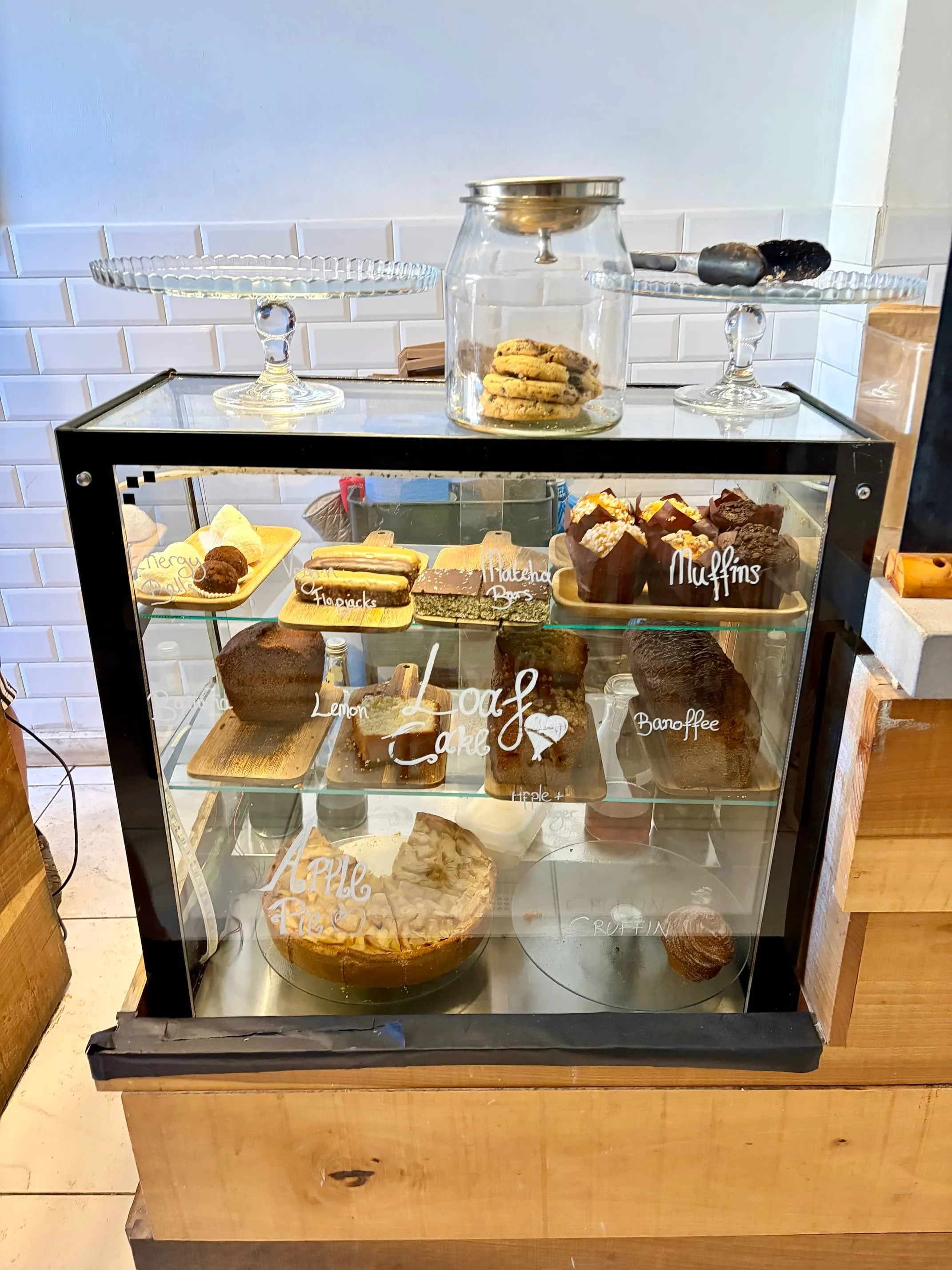 Glass display filled with fresh cakes and pastries at Lot61 Coffee Roasters.