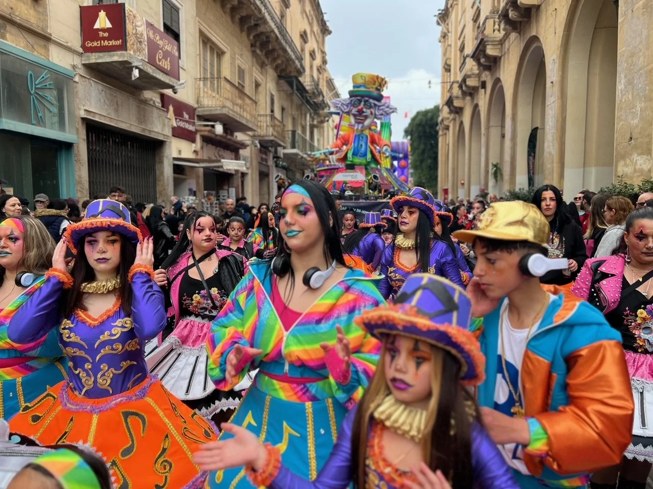 Neon colored dancers in a crowded street in Valletta.