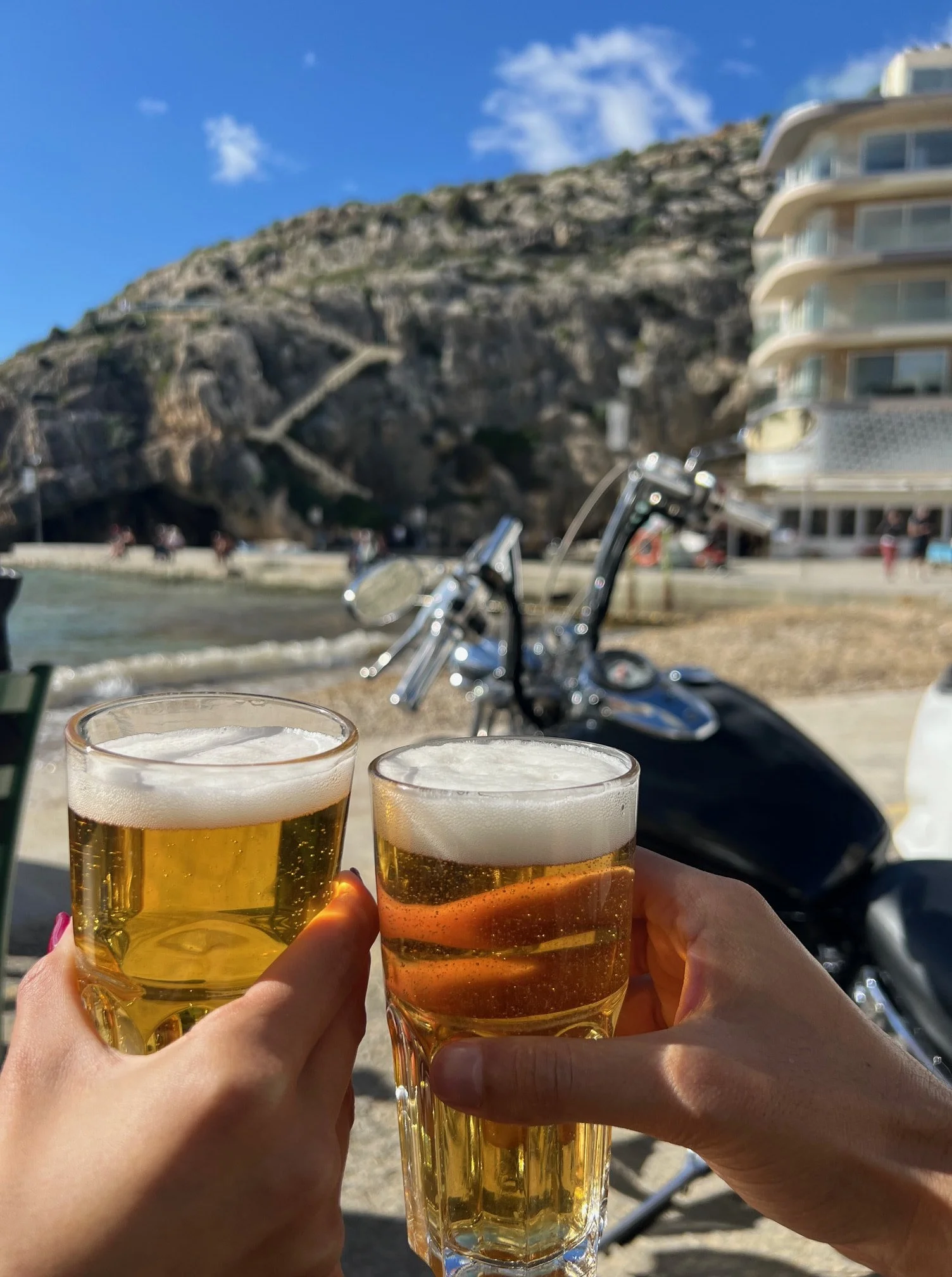 couple-toasting-beers-xlendi-bay-sunshine.jpg