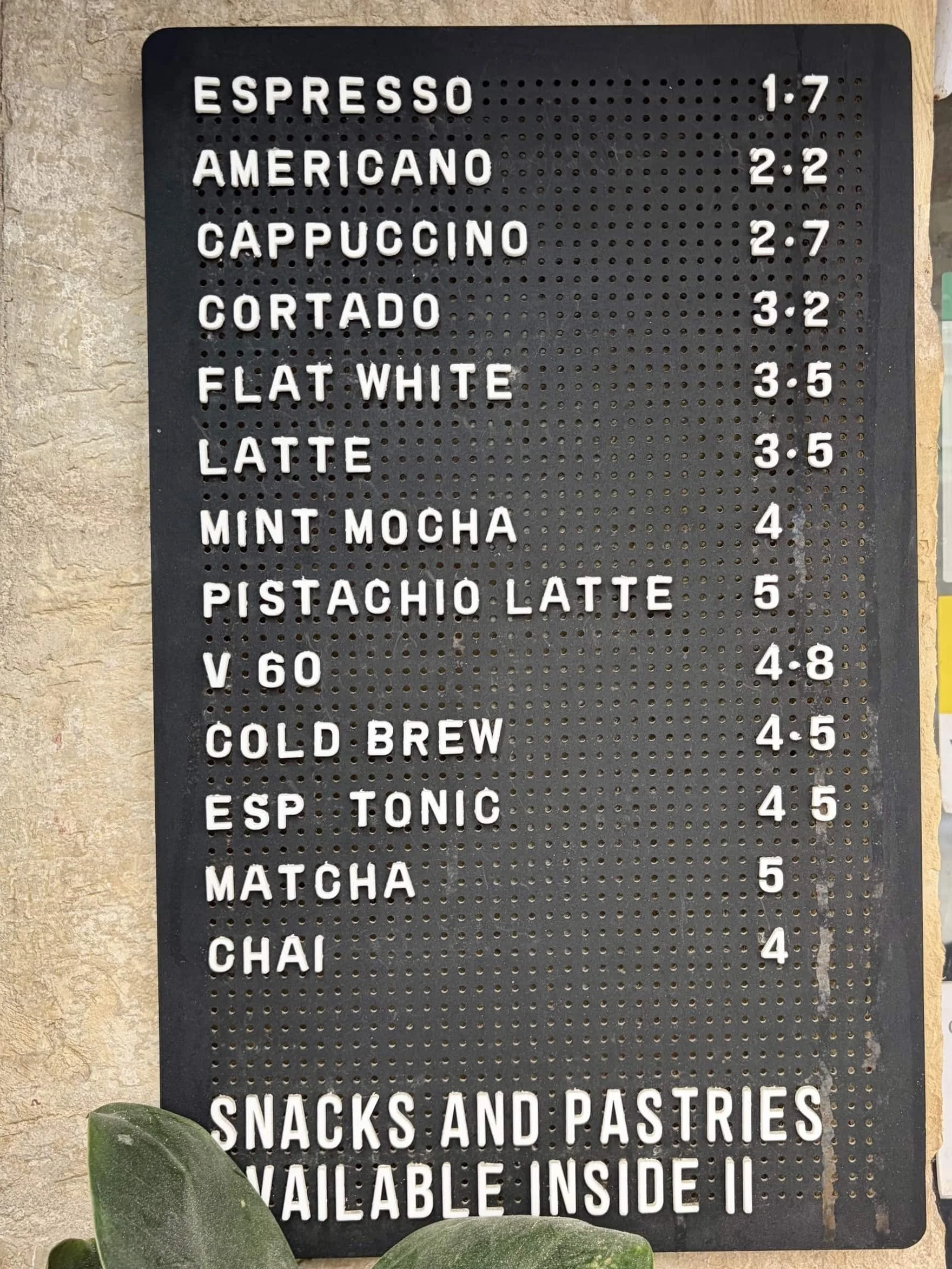 Black letterboard displaying coffee prices and menu items at Kir Royal Café, Valletta.