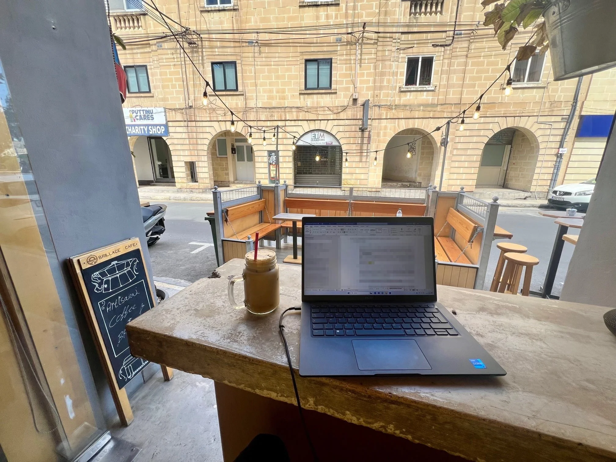 Digital nomad setting with iced latte inside Brillace Cafe, Gzira.