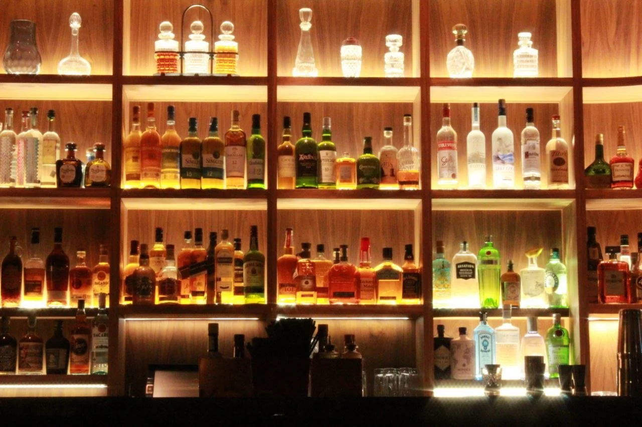 Close-up of refreshing cocktails standing on a counter in a dimly lit, atmospheric bar in Malta.