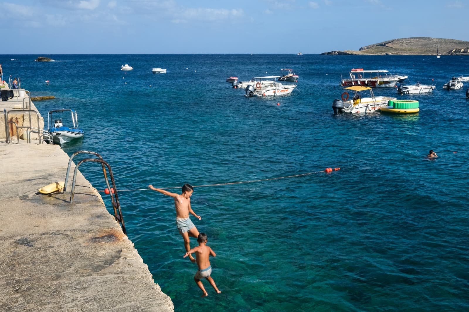 Families and children enjoying the beach day at Hondoq ir-Rummien Bay in Gozo.