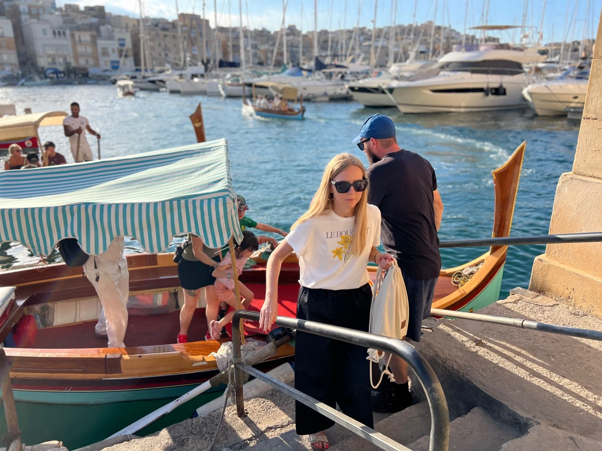 Passengers boarding a traditional Dgħajsa water taxi at the Birgu landing station.